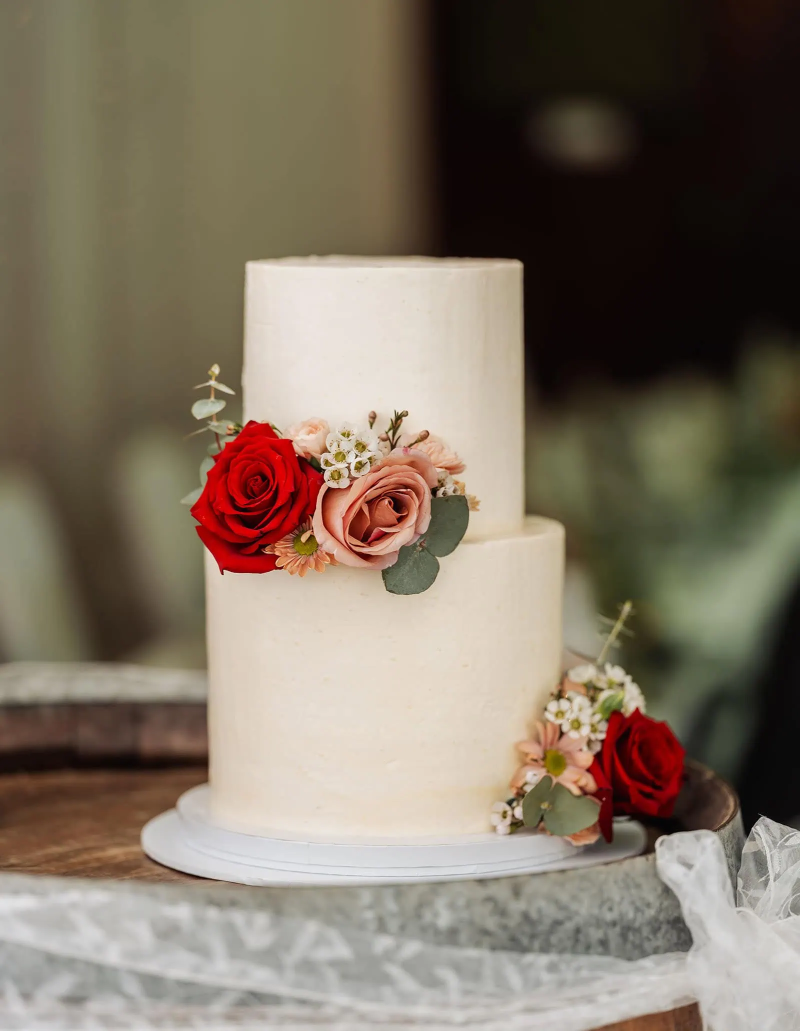 utopia waterfall gully wedding - sally & ben 250 Elegant two-tier cake with floral decorations, perfect for weddings and special events.
