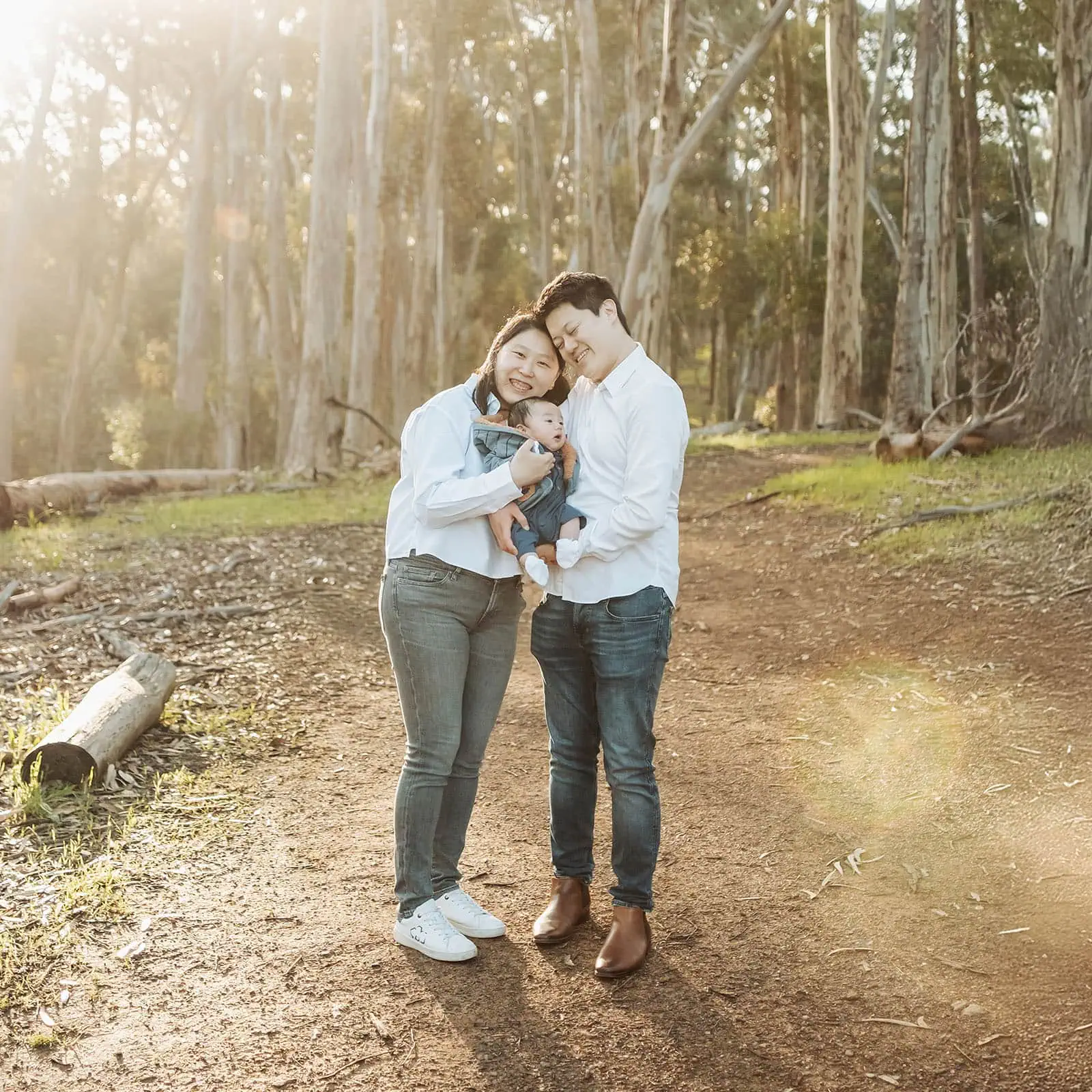 belair family photography 112 Family posing together in a lush green forest, capturing a memorable outdoor moment.
