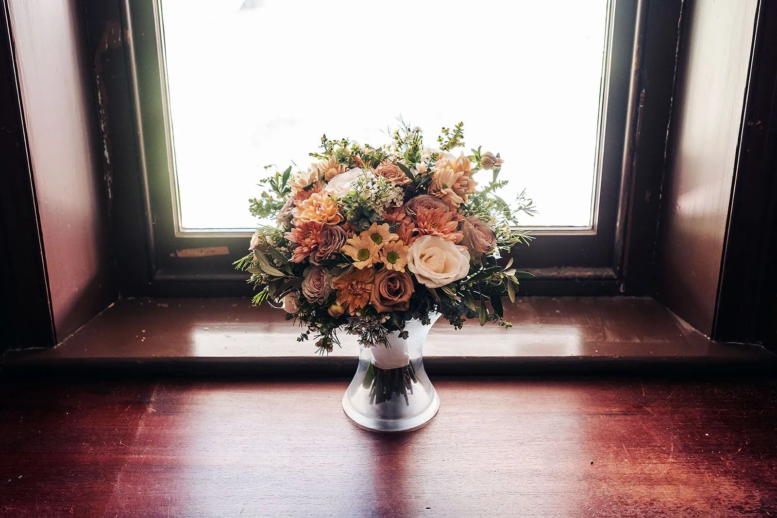 grand cru estate wedding - isabella & nick 106 Sunlit bouquet of vibrant flowers on a windowsill.
