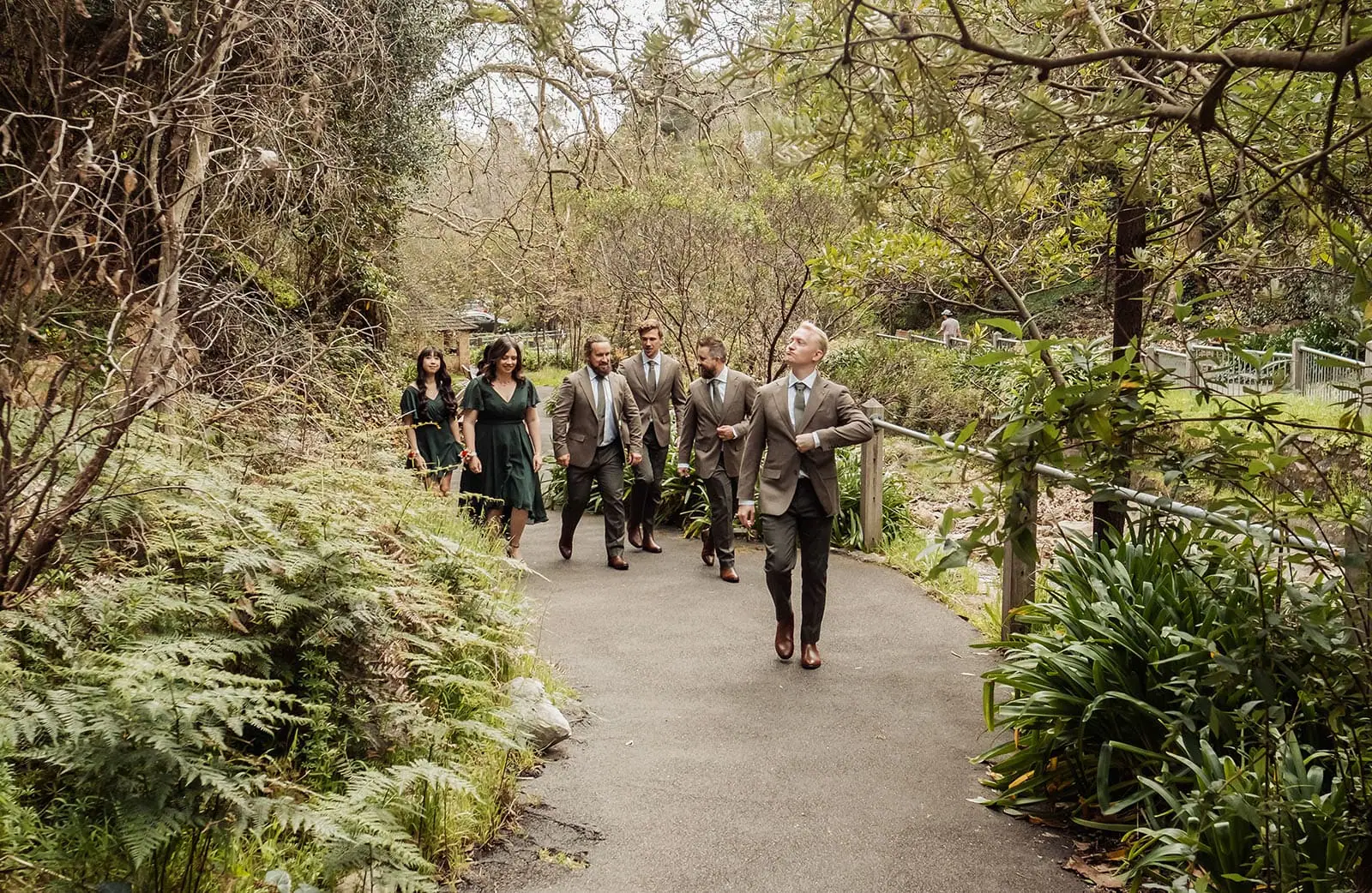 utopia waterfall gully wedding - sally & ben 237 Elegant outdoor event with guests in formal attire surrounded by lush greenery.