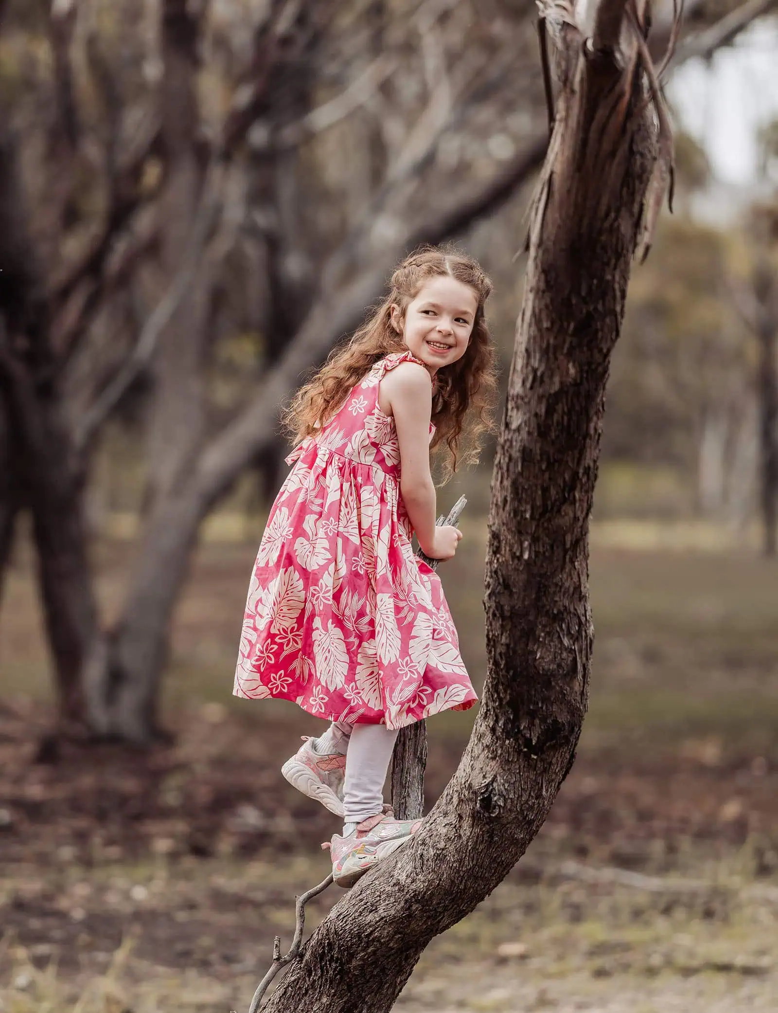 happy valley reservoir family photoshoot 9 Young girl climbing tree in sunny park, enjoying adventure and nature.