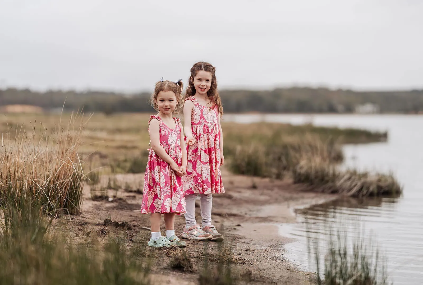 happy valley reservoir family photoshoot 14 Young girls in pink dresses by the water enjoying a sunny day.