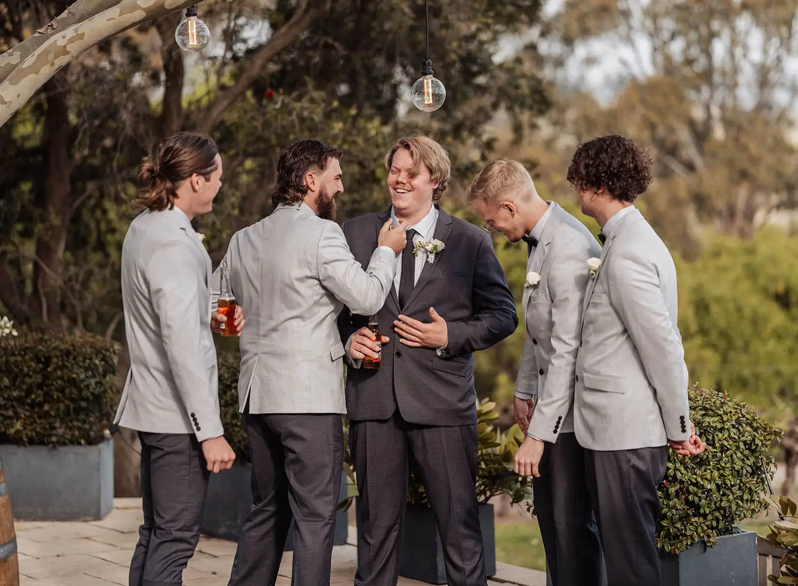 beach rd wines wedding - hana & jessie 50 Groom and groomsmen celebrating at wedding in elegant suits.