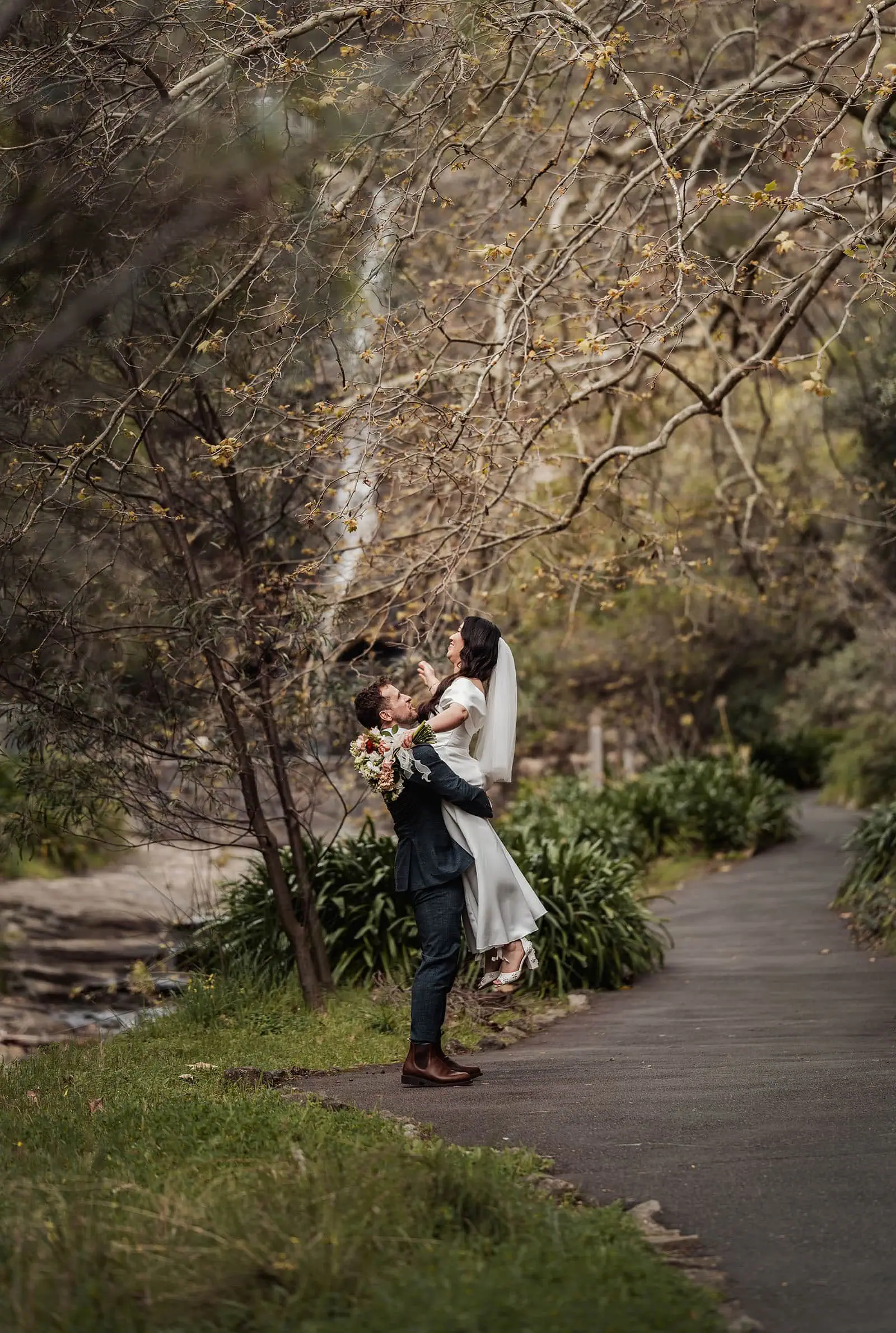 utopia waterfall gully wedding - sally & ben 231 Smiling couple enjoying a nature walk surrounded by greenery.