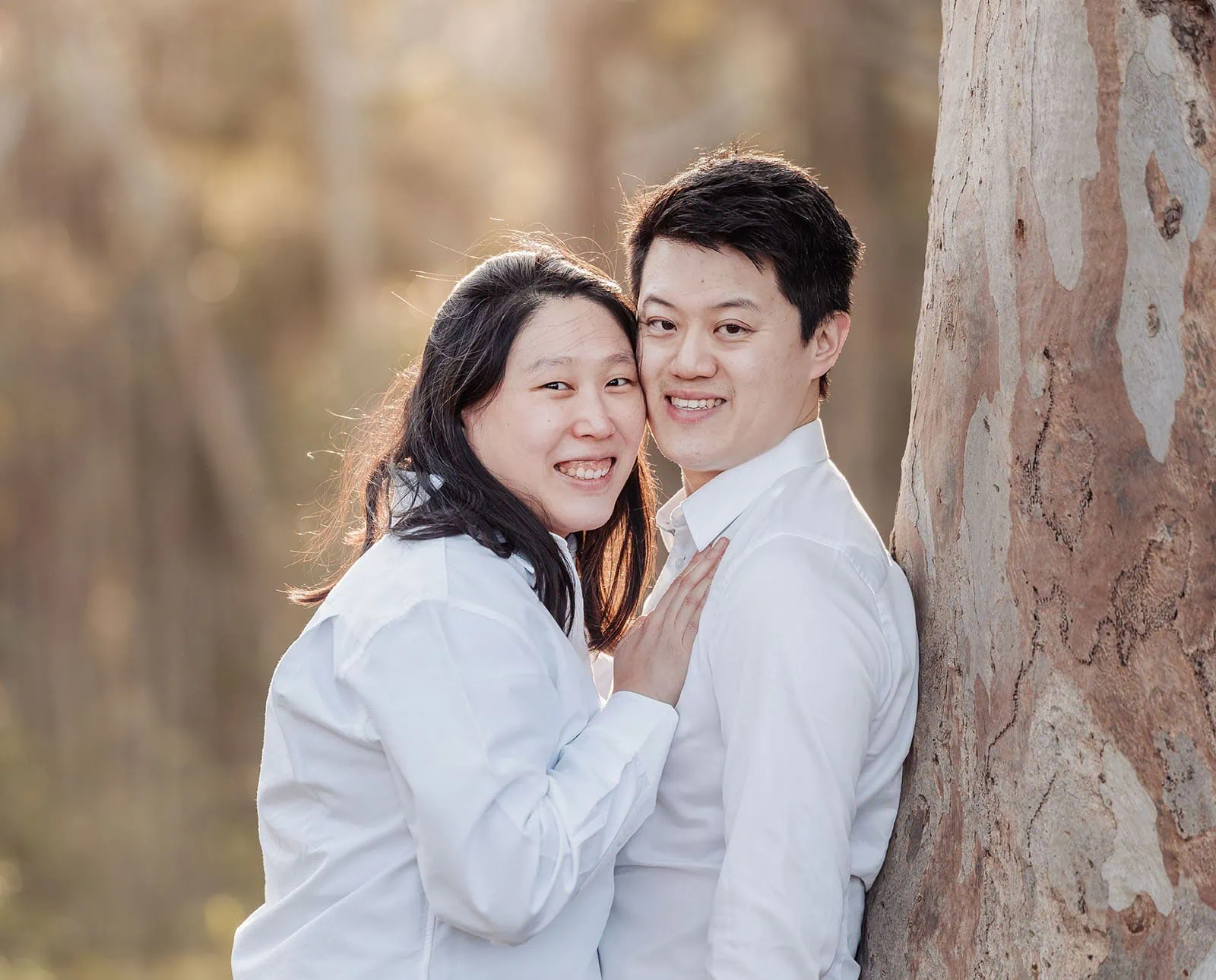 belair family photography 122 Smiling couple sitting under a tree enjoying nature and togetherness.