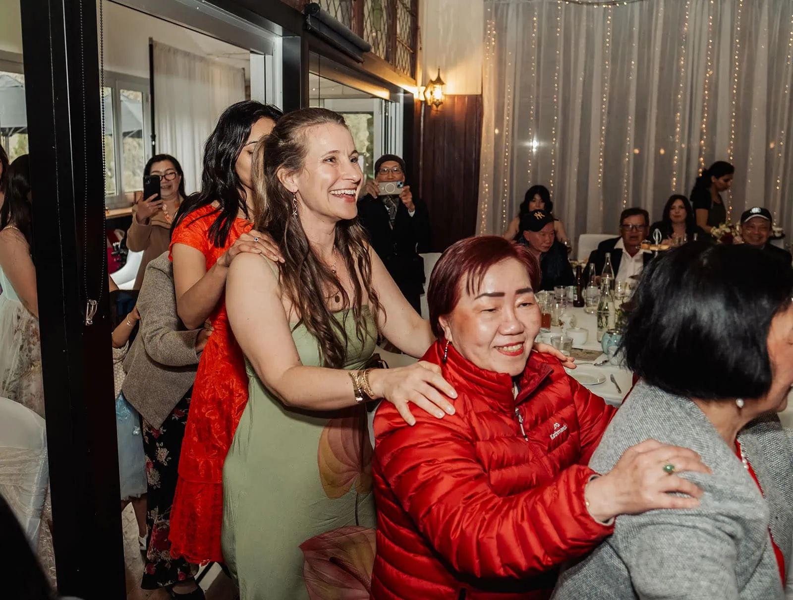 utopia waterfall gully wedding - sally & ben 267 People celebrating in a joyful conga line with laughter and energy.