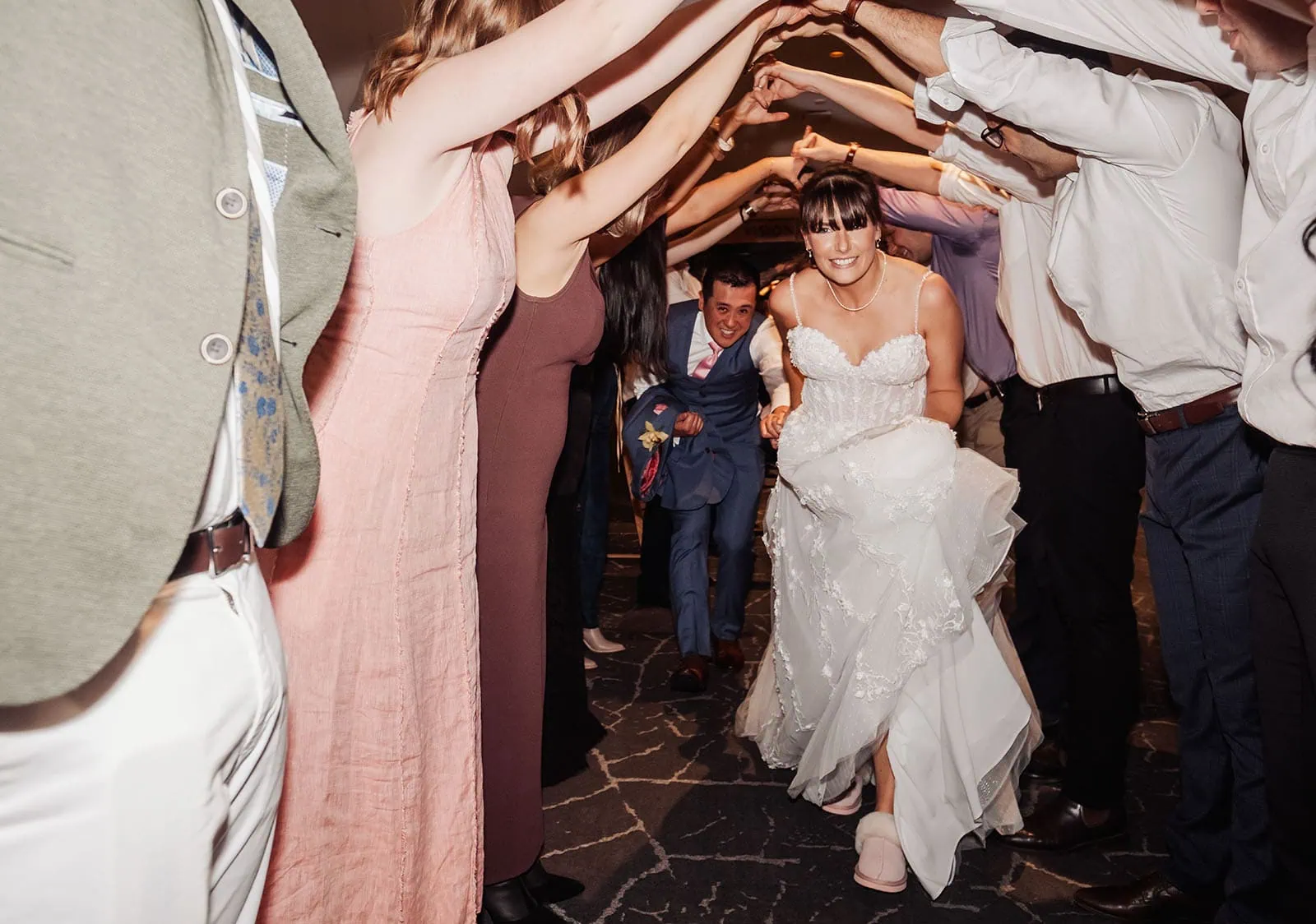 adelaide botanic gardens summerhouse wedding - belinda & ian 213 Wedding guests form joyful tunnel for newlyweds, celebrating love and happiness.