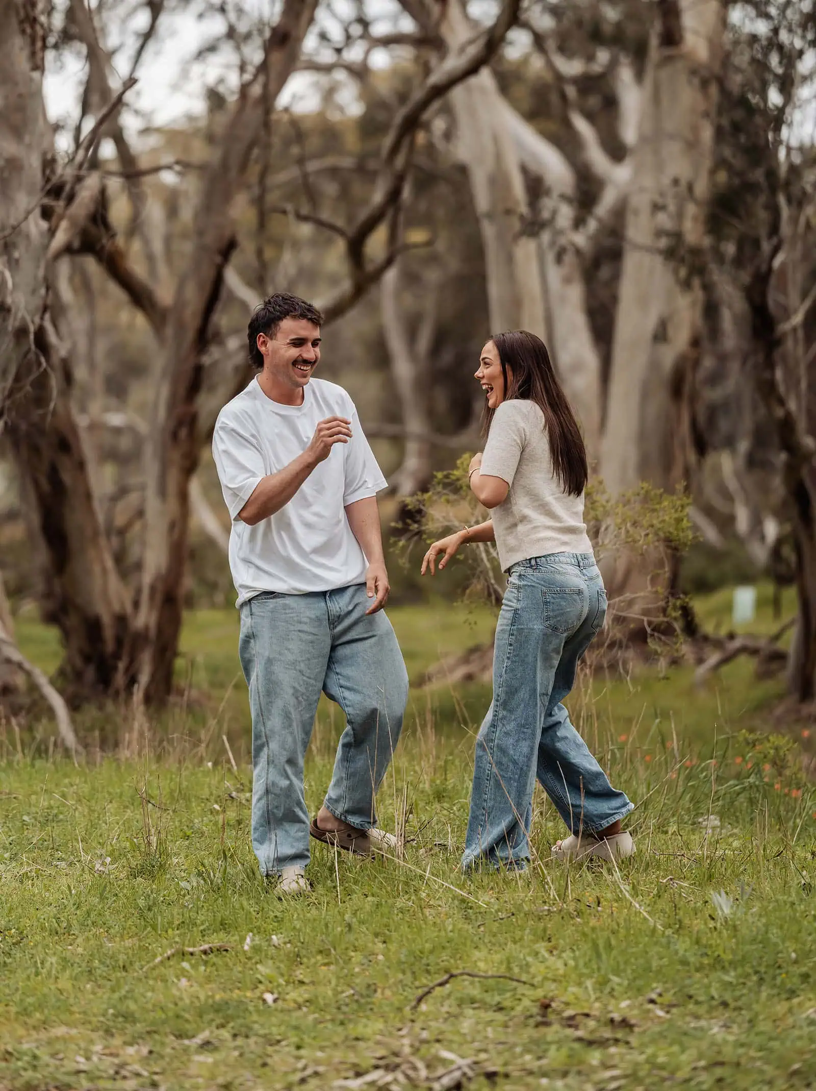 myponga family photography 8 Couple laughing joyfully outdoors in nature, surrounded by greenery.