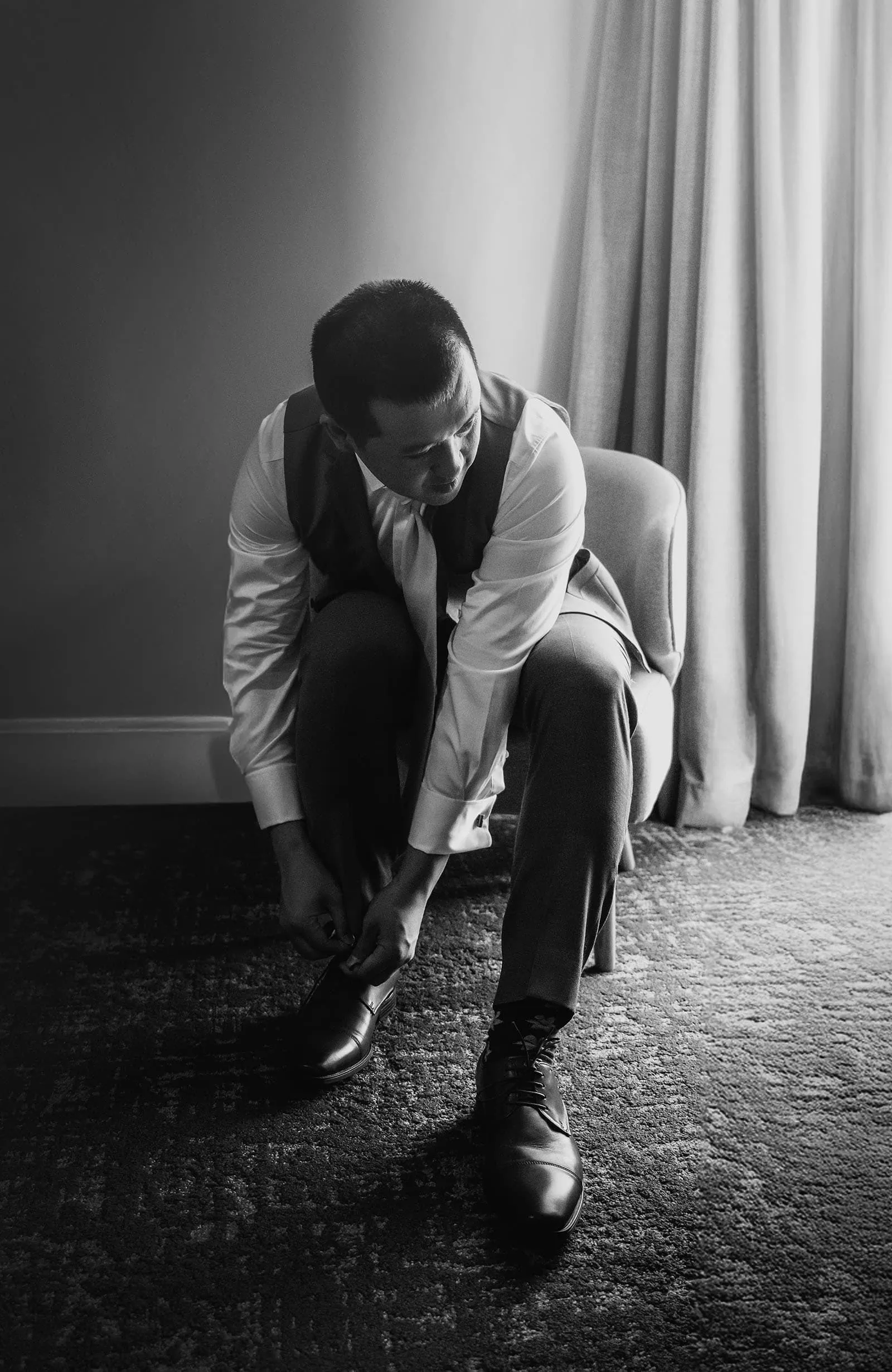 adelaide botanic gardens summerhouse wedding - belinda & ian 126 Man tying shoelaces on running shoes, outdoor fitness preparation scene.