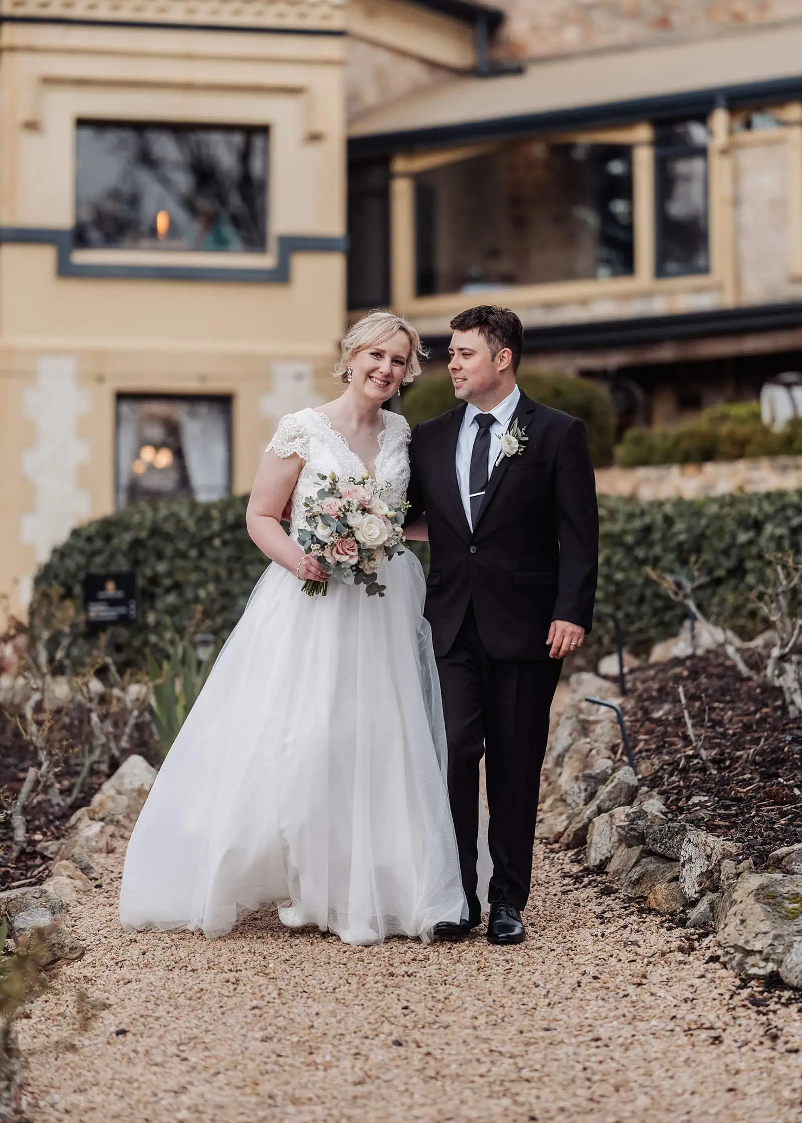 mt lofty house elopement - kimberley & michael 213 Newlyweds stroll down a picturesque rustic path, surrounded by nature and romance.