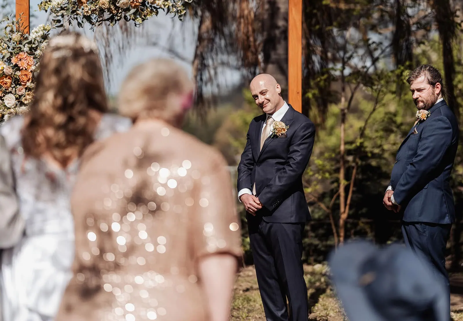 grand cru estate wedding - isabella & nick 121 Elegant outdoor wedding ceremony under a clear sky with floral decorations.