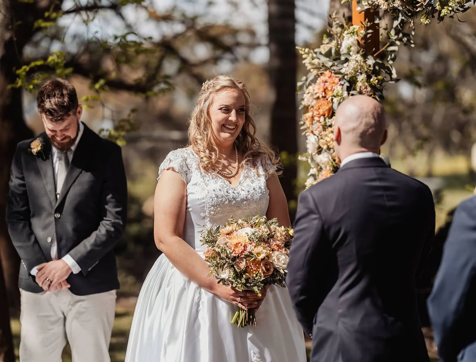 grand cru estate wedding - isabella & nick 125 Scenic outdoor wedding ceremony with floral decorations and guests seated under string lights.