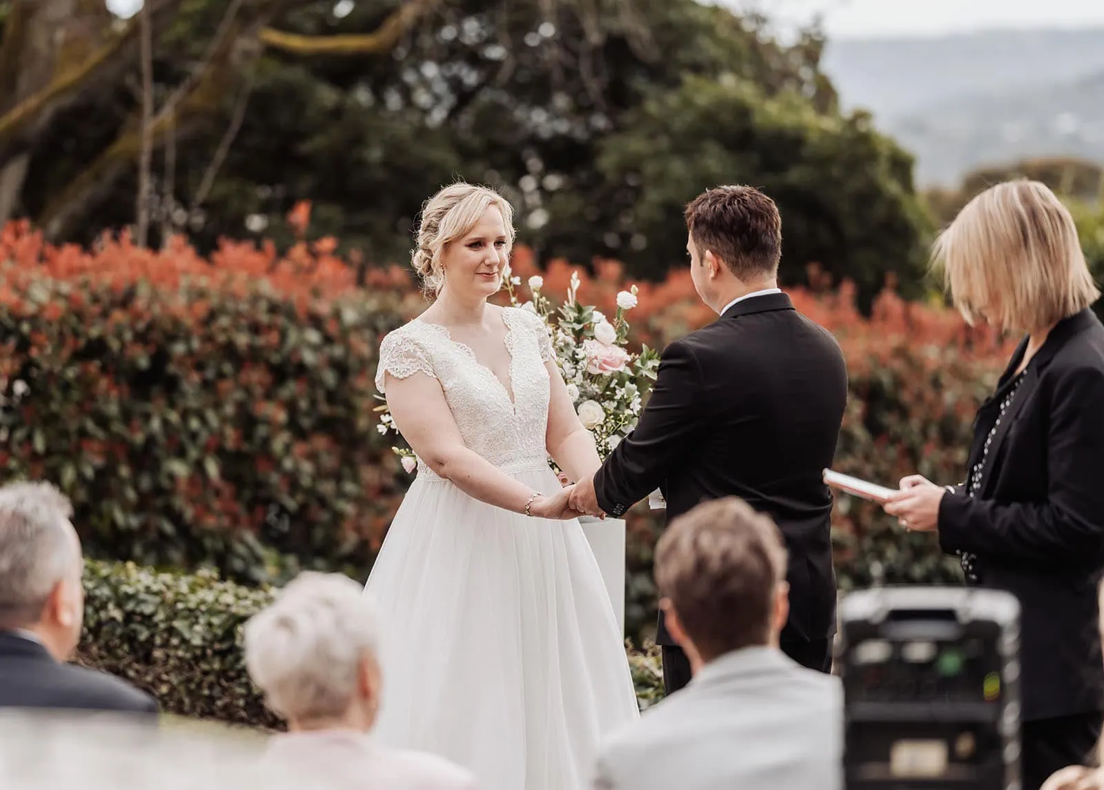 mt lofty house elopement - kimberley & michael 181 Scenic outdoor wedding ceremony with floral decorations and guests seated under a sunny sky.