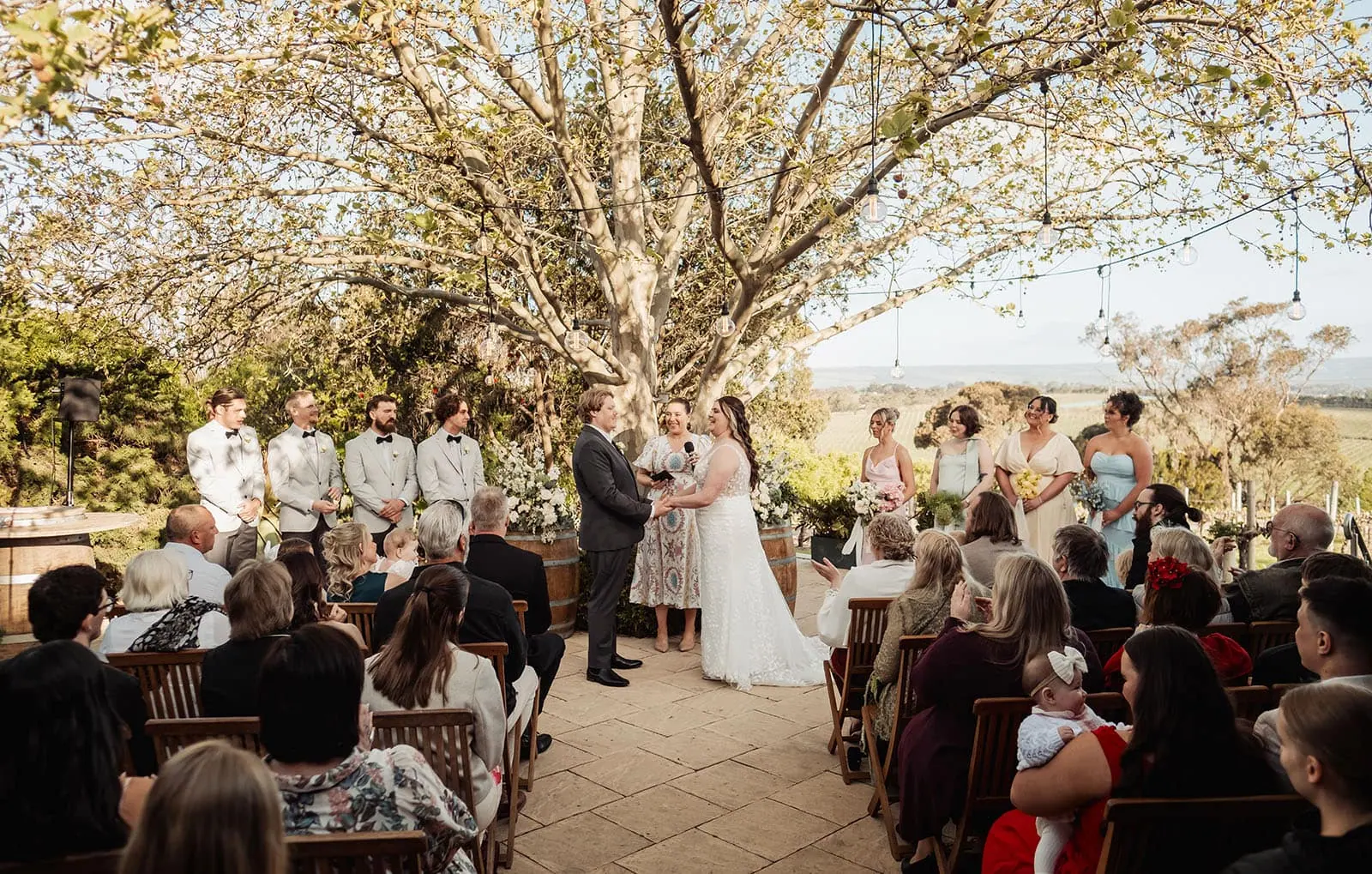 beach rd wines wedding - hana & jessie 60 Scenic outdoor wedding ceremony with elegant decorations and lush greenery.