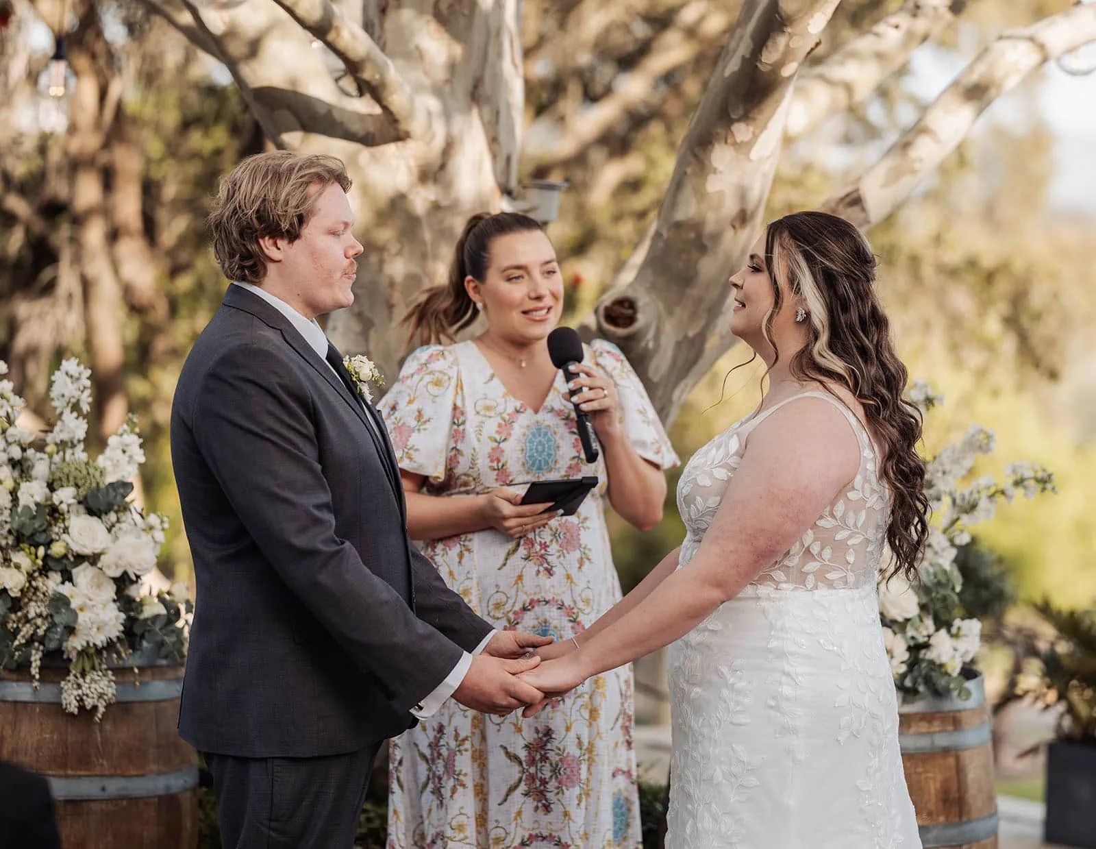 beach rd wines wedding - hana & jessie 61 Beautiful outdoor wedding ceremony under a floral arch with guests in attendance.