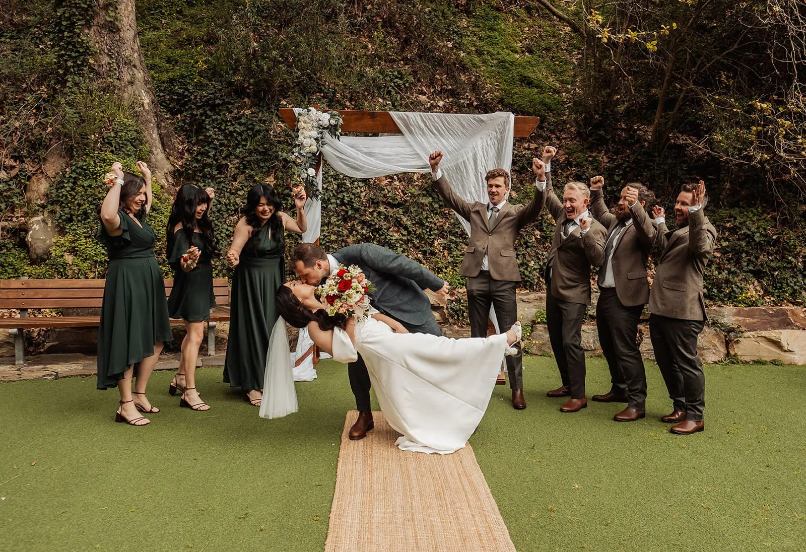 utopia waterfall gully wedding - sally & ben 230 Bride and groom share a kiss at scenic outdoor wedding ceremony.