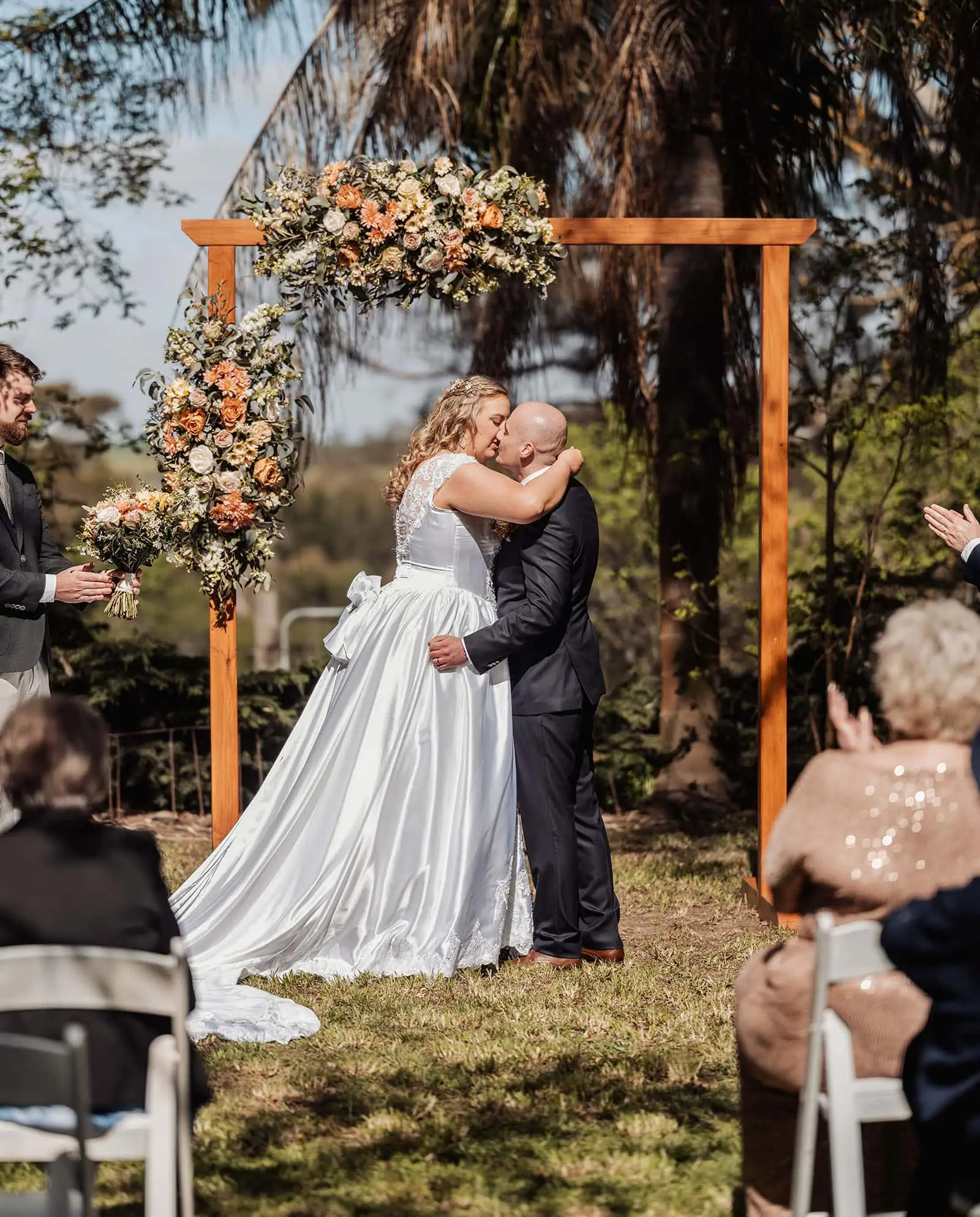 grand cru estate wedding - isabella & nick 128 Bride and groom share a romantic kiss at an outdoor wedding ceremony.
