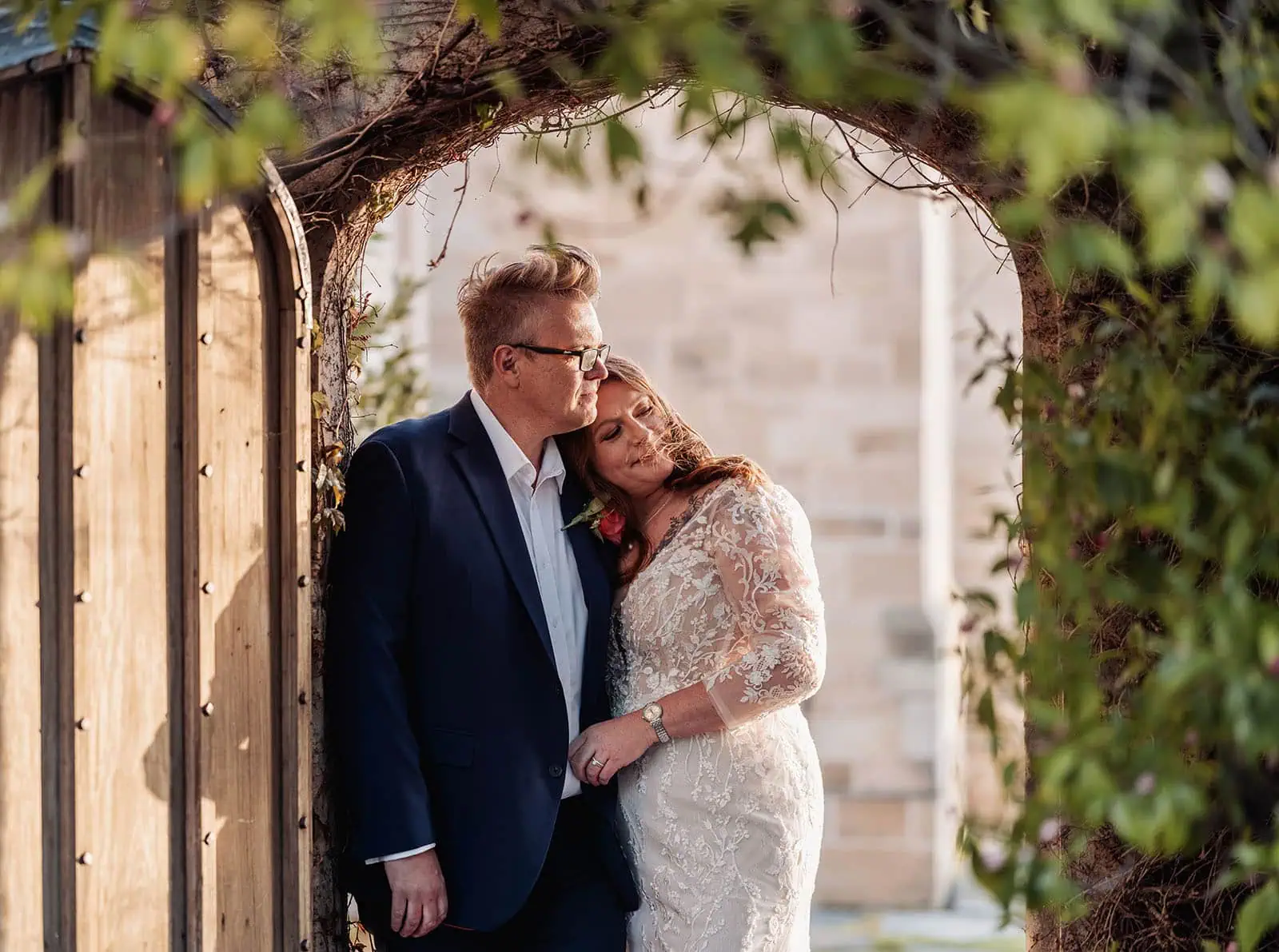carrick hill wedding - jo & david 301 Romantic couple embraces under scenic archway, capturing love and intimacy.