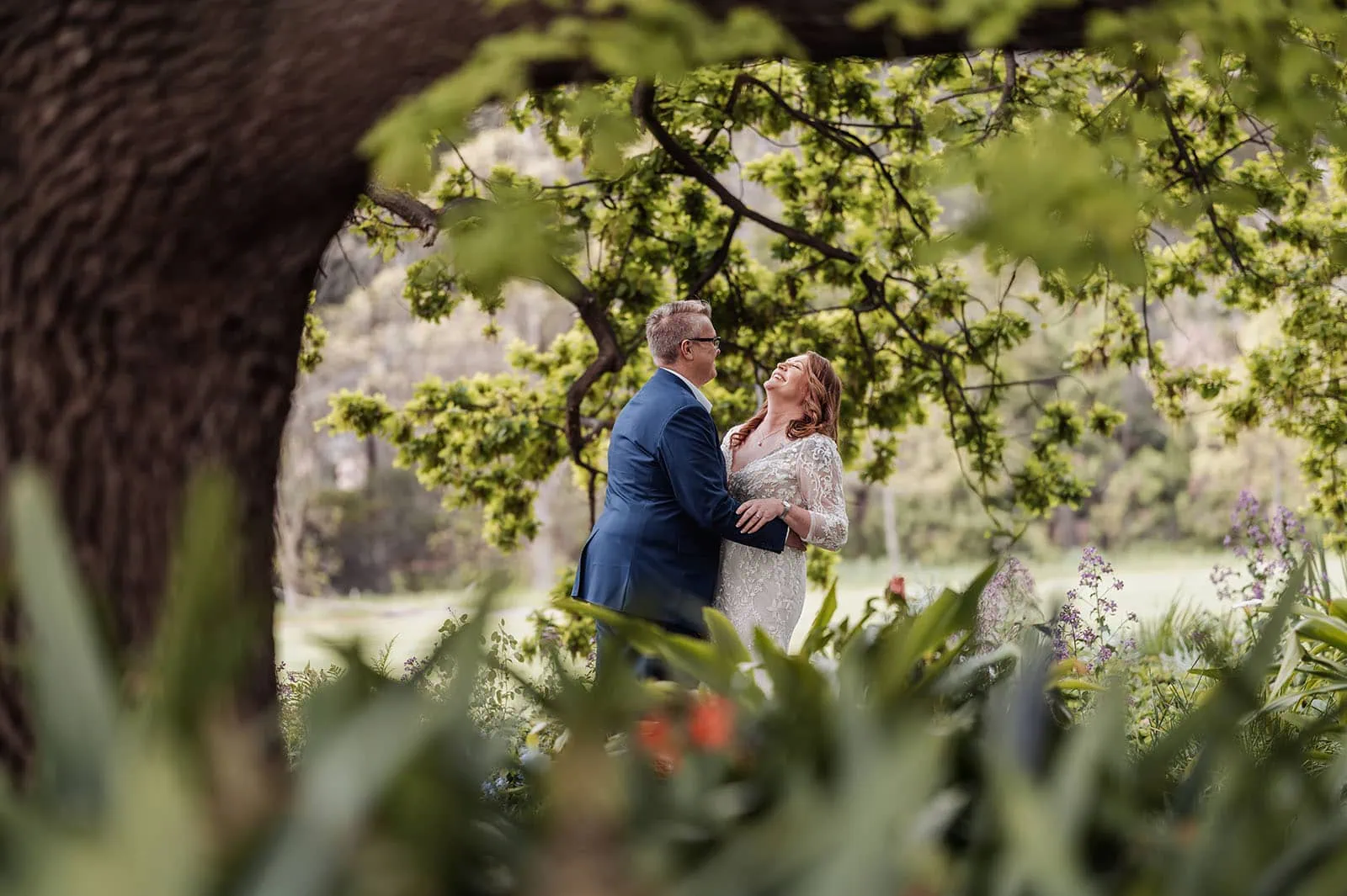 carrick hill wedding - jo & david 283 Couple sharing a romantic moment under a tree at sunset.