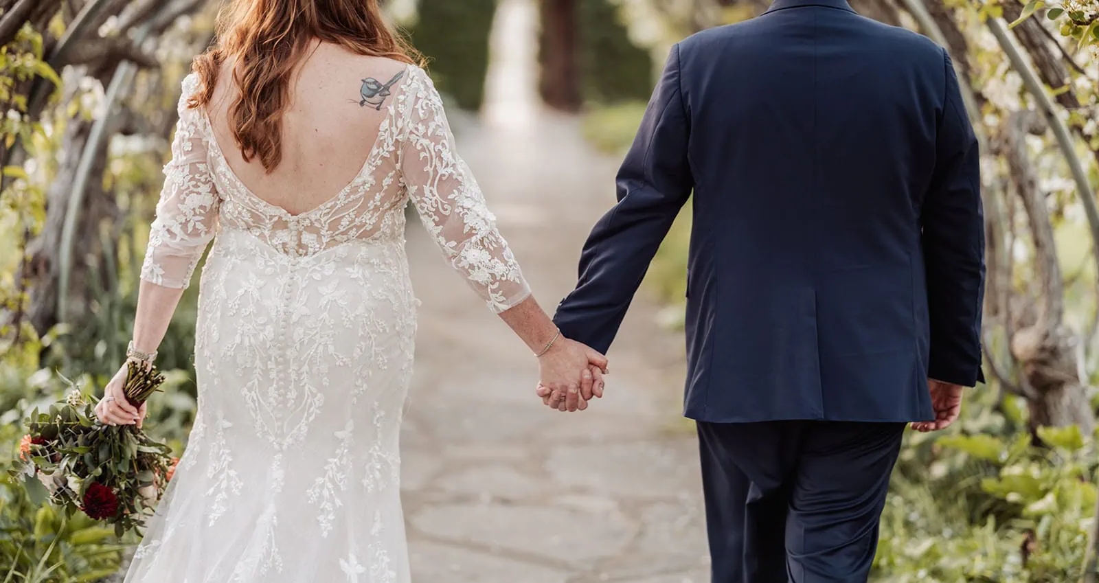 carrick hill wedding - jo & david 305 Romantic couple walking hand in hand through a picturesque park during sunset.