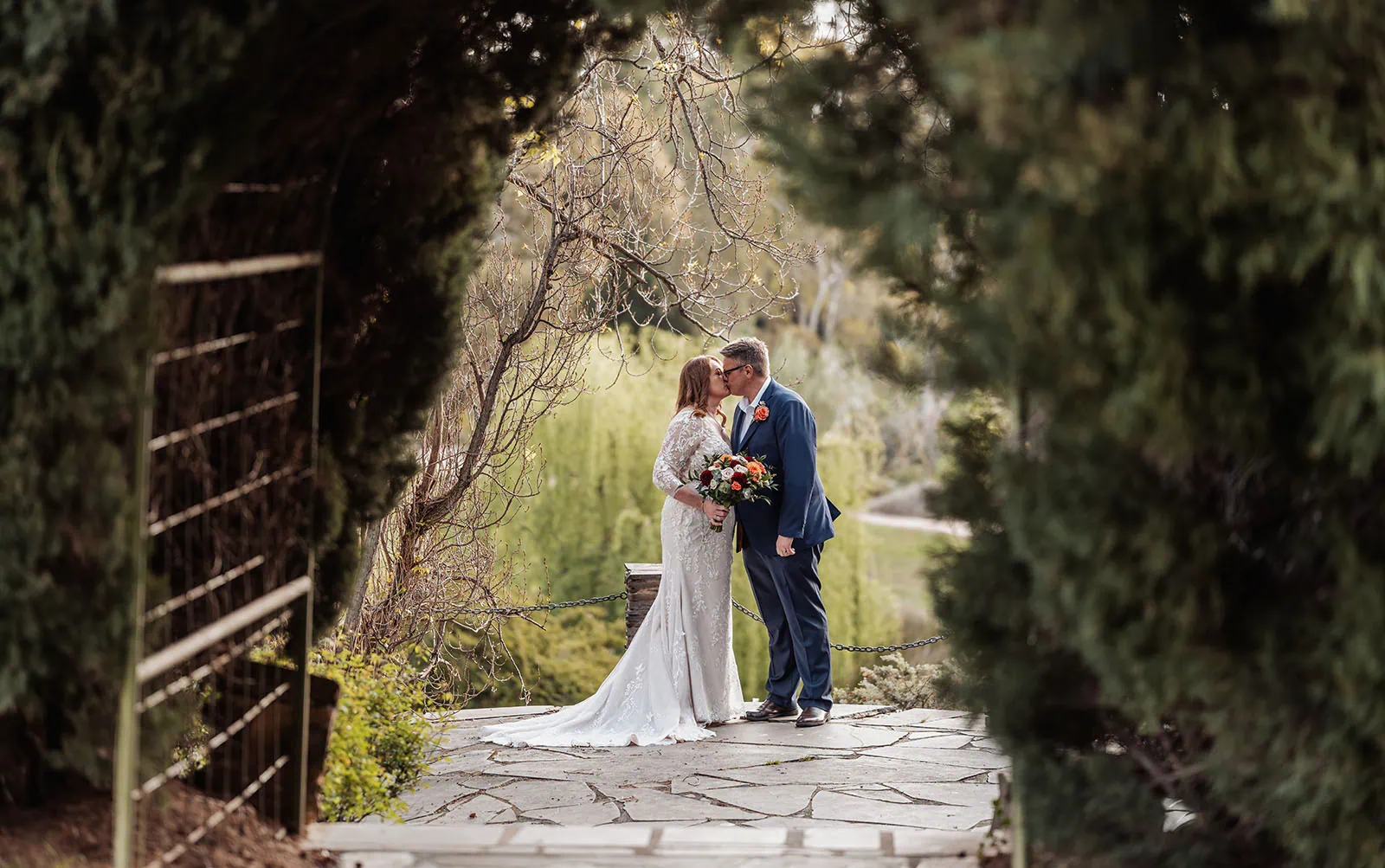 carrick hill wedding - jo & david 288 Couple kissing in lush garden setting, romance and nature theme.