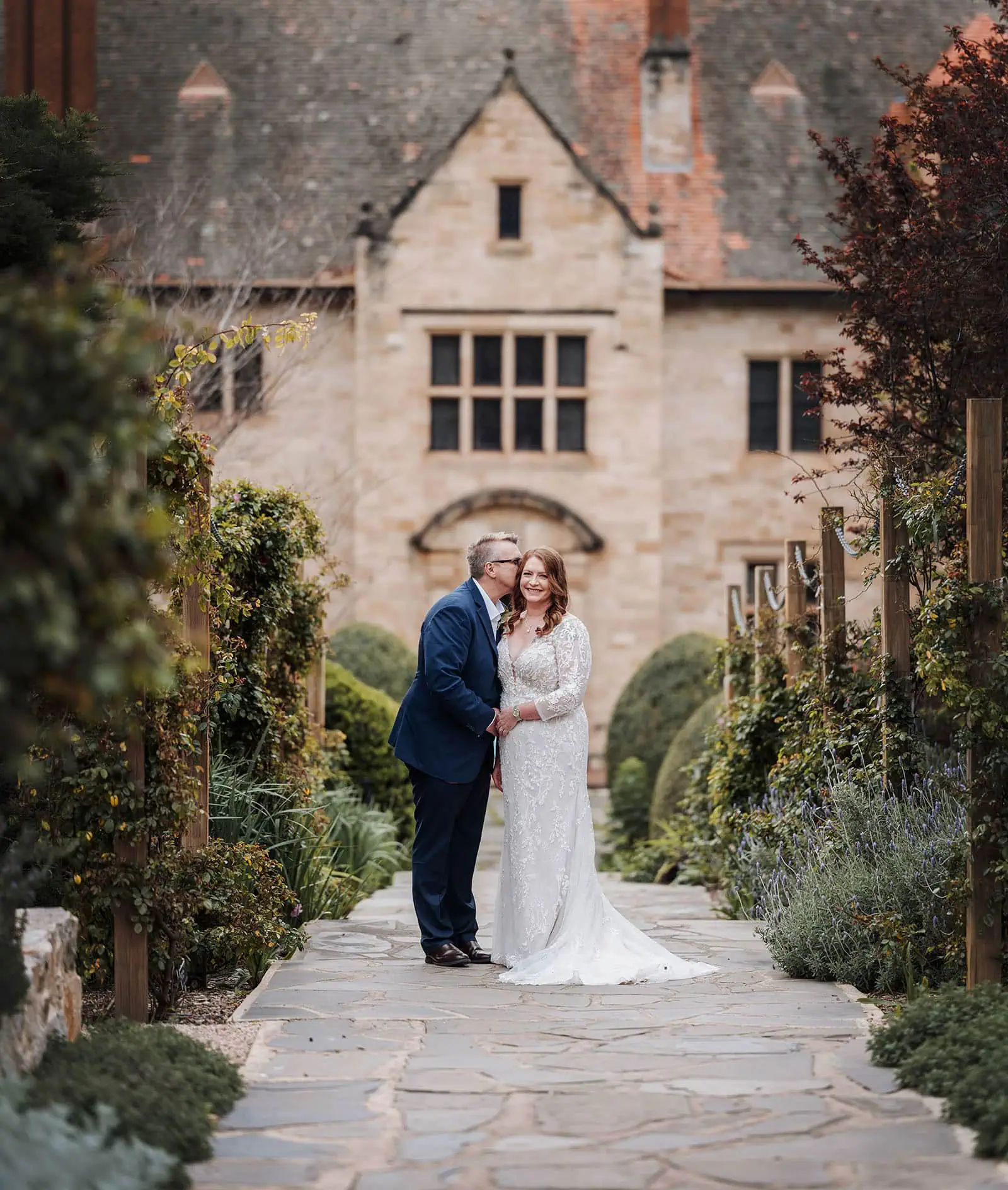 carrick hill wedding - jo & david 280 Romantic garden wedding scene with flowers, arch, and elegant decor.