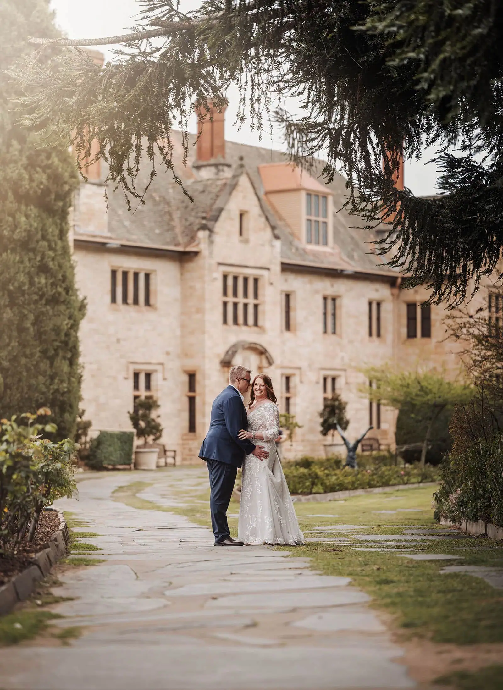 carrick hill wedding - jo & david 277 Elegant outdoor wedding ceremony with floral decorations and a joyful couple.