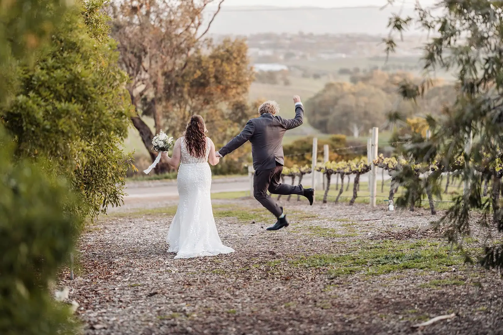 beach rd wines wedding - hana & jessie 76 Couple celebrating wedding in picturesque vineyard setting.