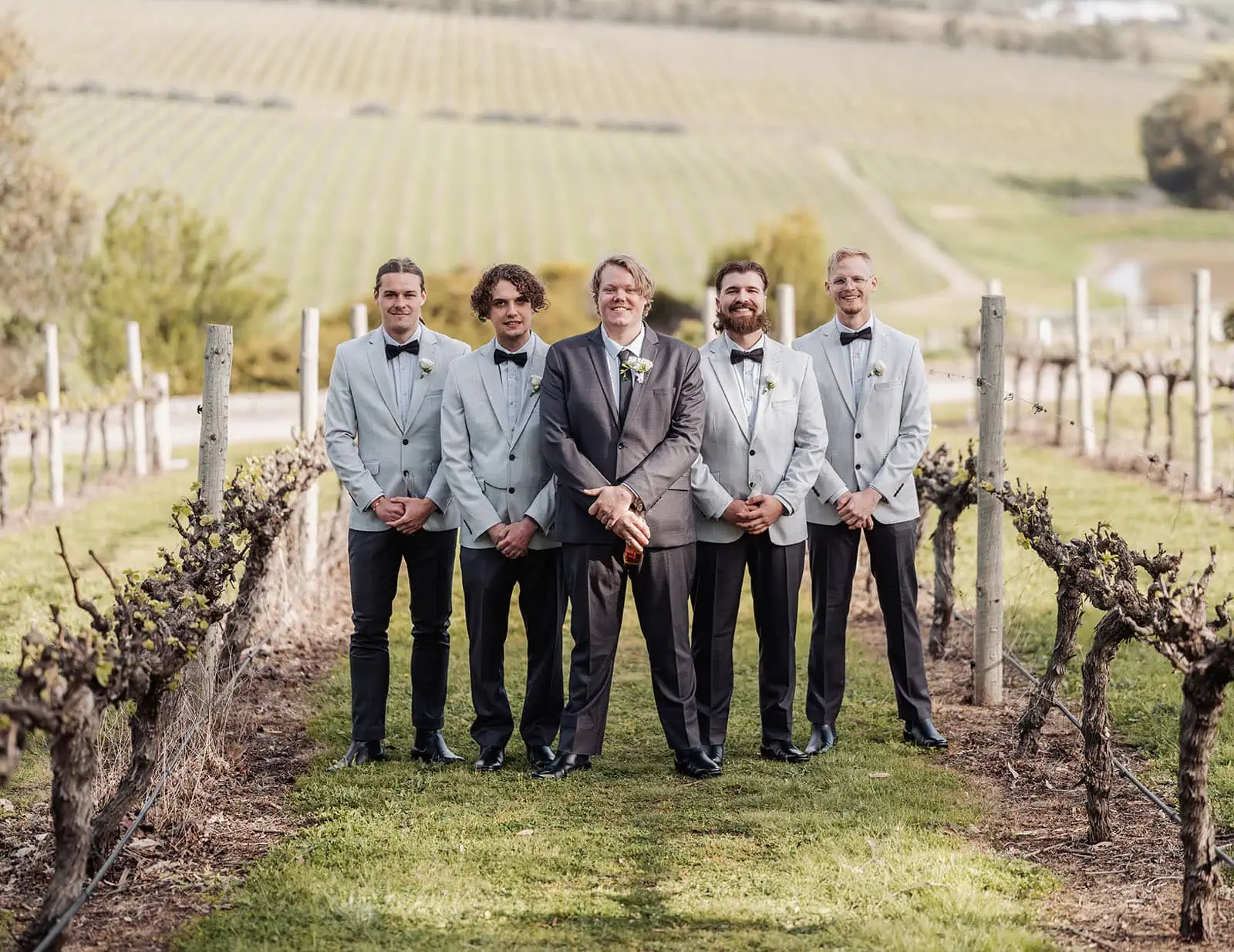 beach rd wines wedding - hana & jessie 51 Bride and groom with wedding party at scenic vineyard setting.