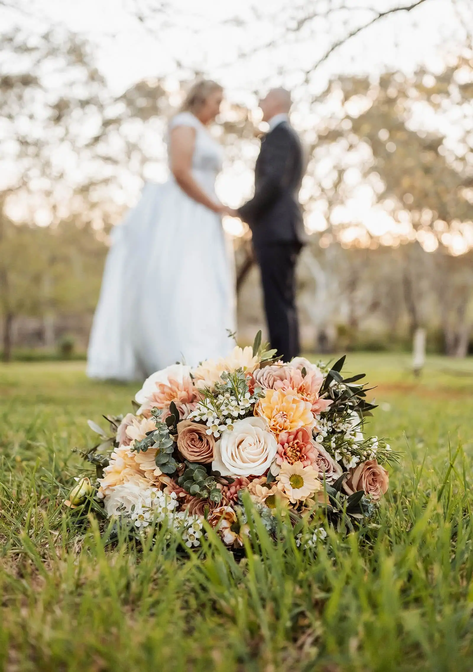 grand cru estate wedding - isabella & nick 148 Bride and groom holding a vibrant wedding bouquet in elegant attire.