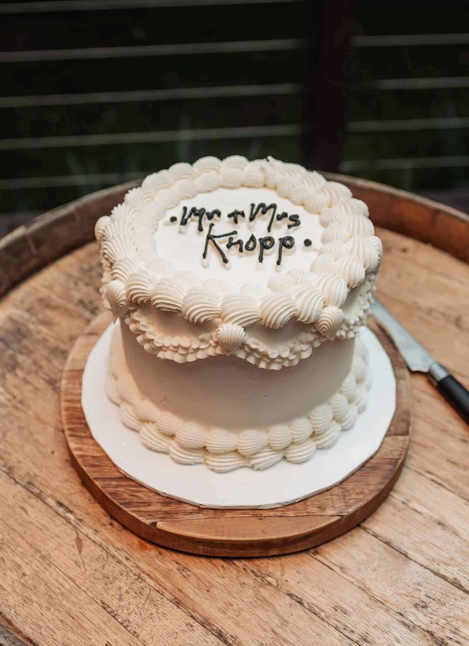 beach rd wines wedding - hana & jessie 87 Elegant wedding cake with Mr. & Mrs. Knopp topper, featuring floral decorations.