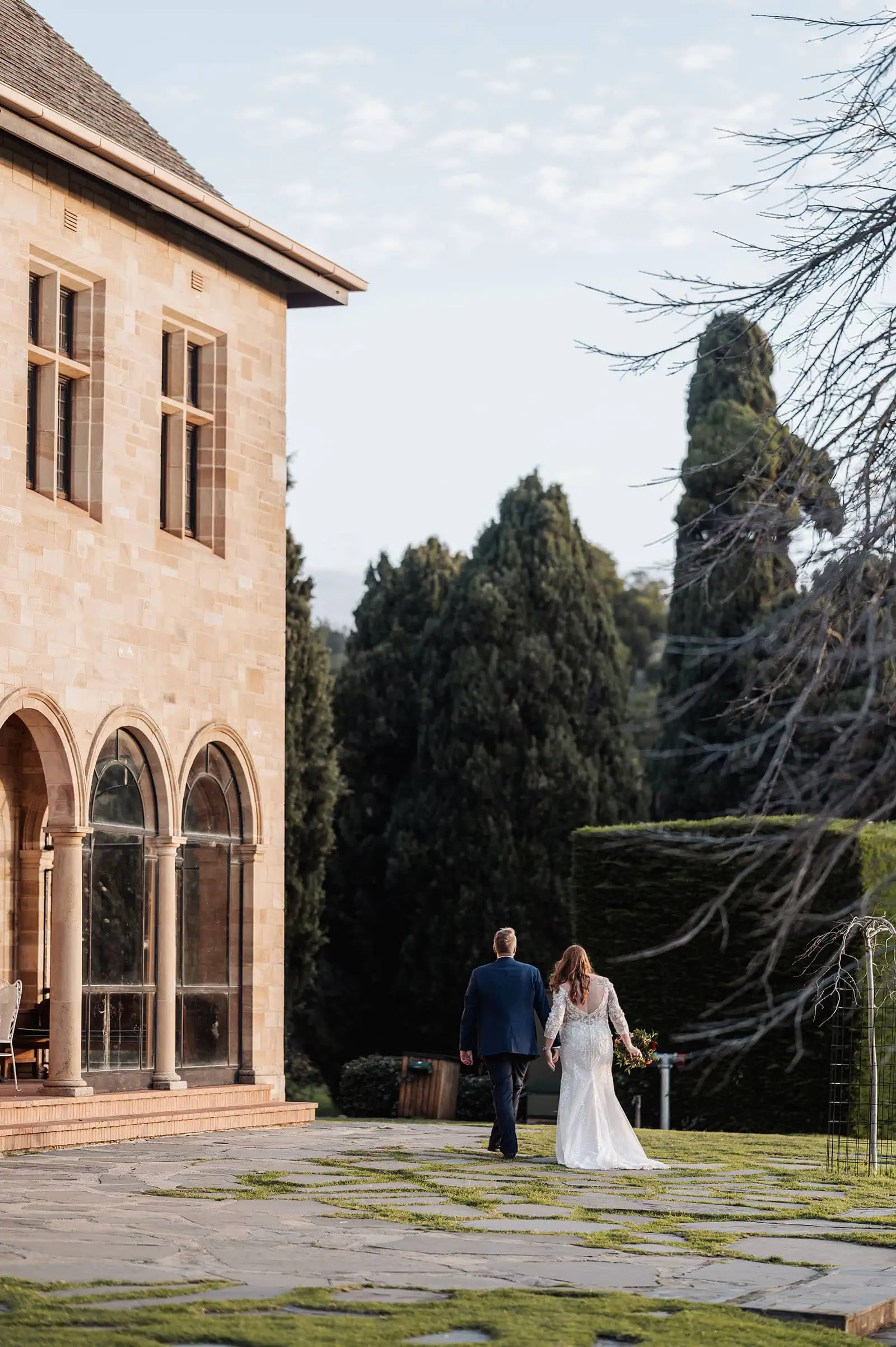 carrick hill wedding - jo & david 302 Wedding couple embracing by a historic building backdrop.
