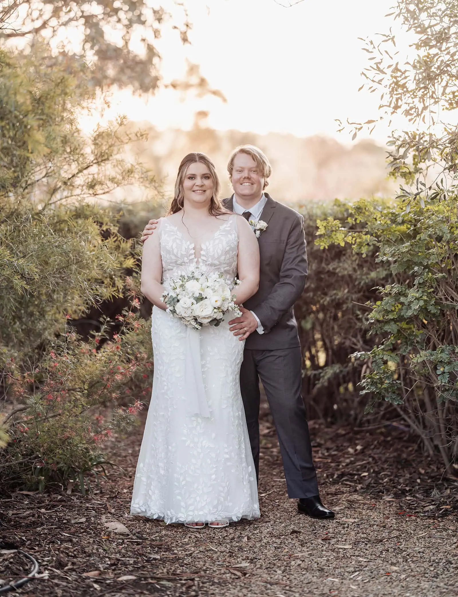 beach rd wines wedding - hana & jessie 74 Elegant bride and groom embrace outdoors, celebrating their wedding day.