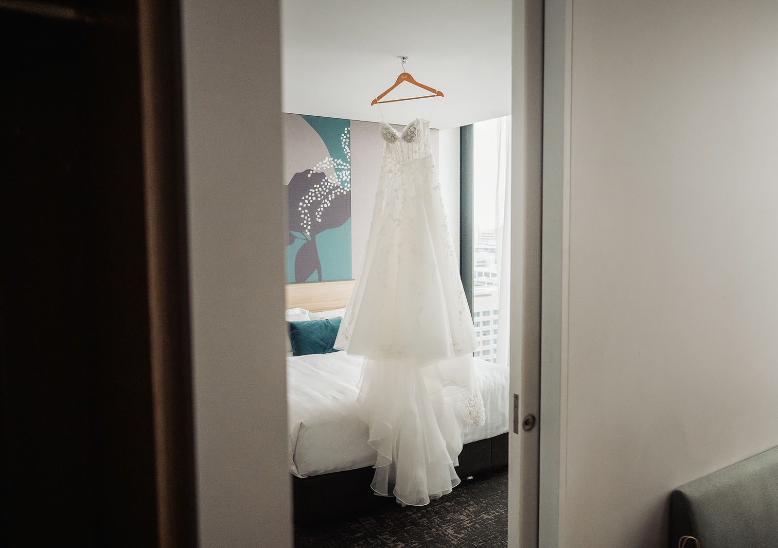 adelaide botanic gardens summerhouse wedding - belinda & ian 137 Bride admiring wedding dress in elegant bedroom setting.