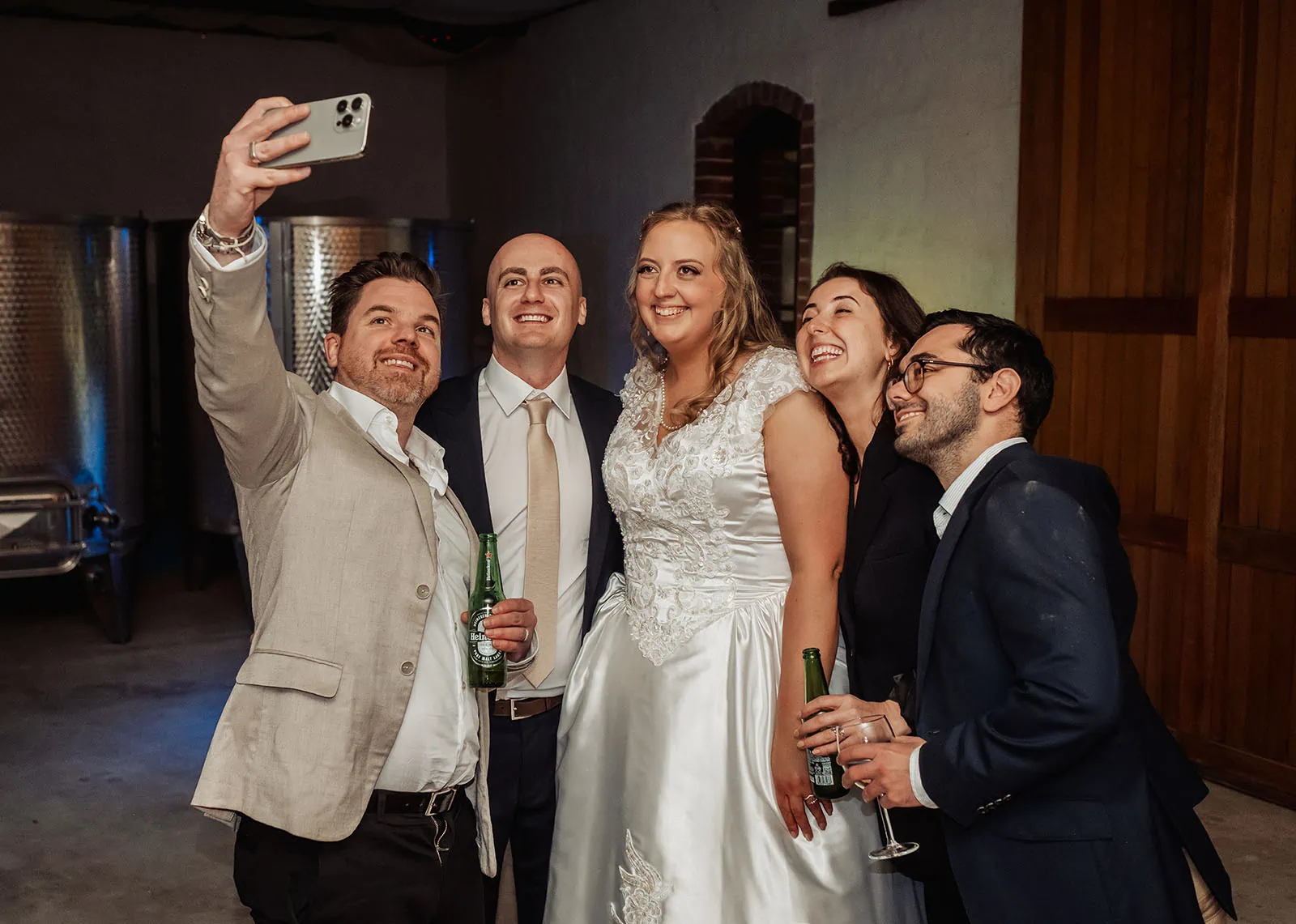 grand cru estate wedding - isabella & nick 164 Wedding party group selfie capturing smiles and joy during celebration.