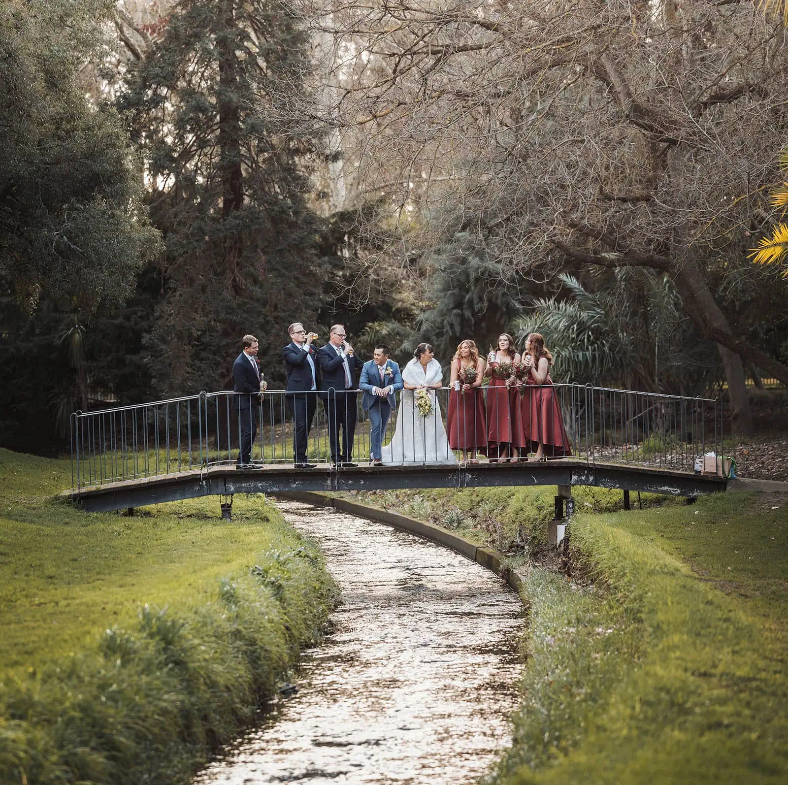 adelaide botanic gardens summerhouse wedding - belinda & ian 188 Bride and groom standing on a scenic bridge during wedding ceremony.