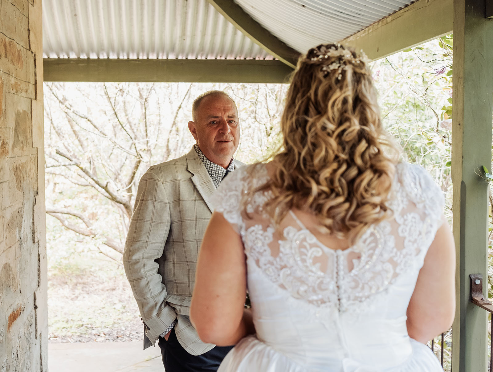 grand cru estate wedding - isabella & nick 114 Bride and groom embrace on scenic veranda during sunset wedding ceremony.