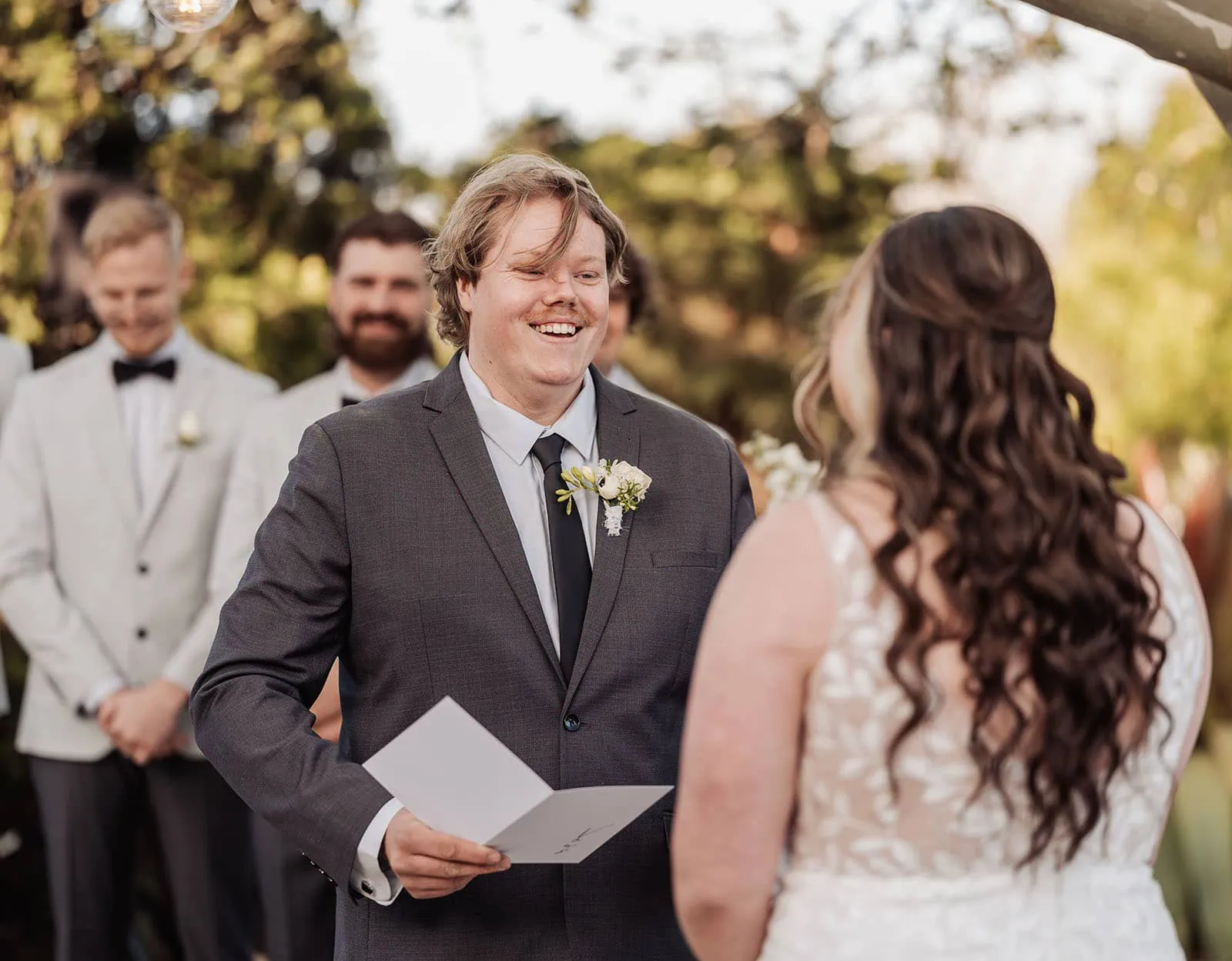 beach rd wines wedding - hana & jessie 64 Outdoor wedding ceremony with couple exchanging vows under a floral arch.