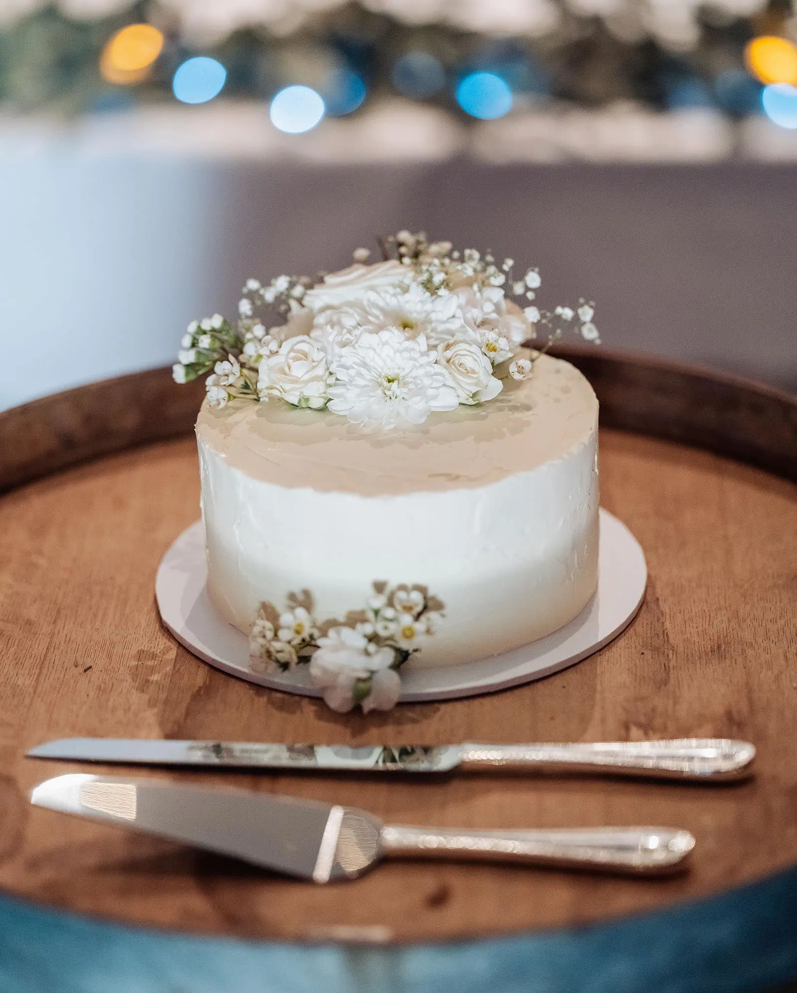 grand cru estate wedding - isabella & nick 153 White cake with floral decorations in top view.