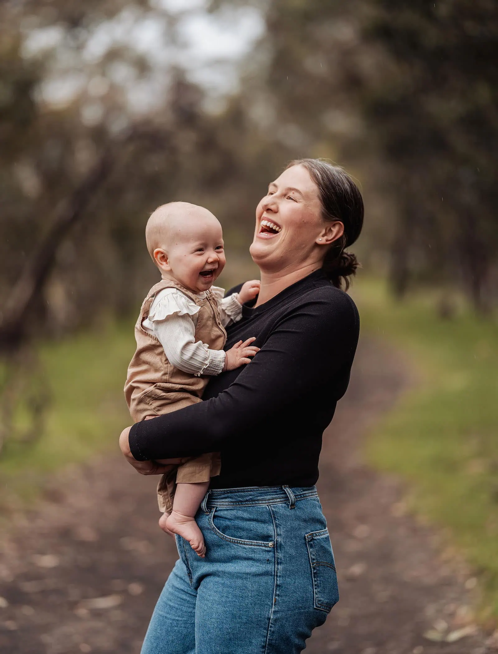 myponga family photography 29 Woman smiling with baby, capturing joyful bonding moment.