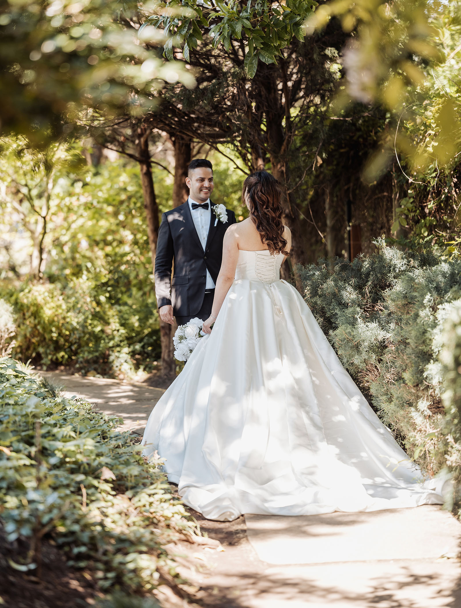 sunnybrae rose garden wedding - celina & anuj 23 Bride and groom sharing vows at a scenic outdoor wedding ceremony.