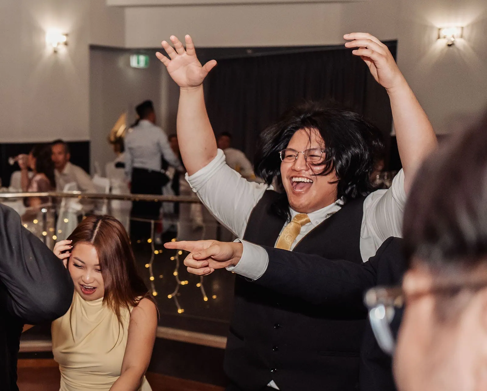 sunnybrae rose garden wedding - celina & anuj 87 Festive dance party with colorful lights and energetic crowd celebrating music and joy.