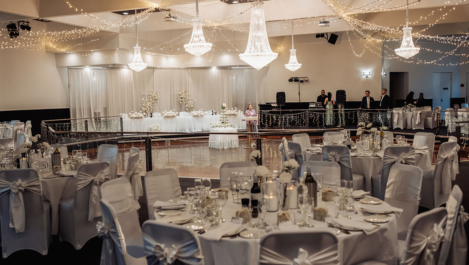 sunnybrae rose garden wedding - celina & anuj 66 Elegant banquet hall with chandelier, luxurious seating, and grand decor for weddings and events.