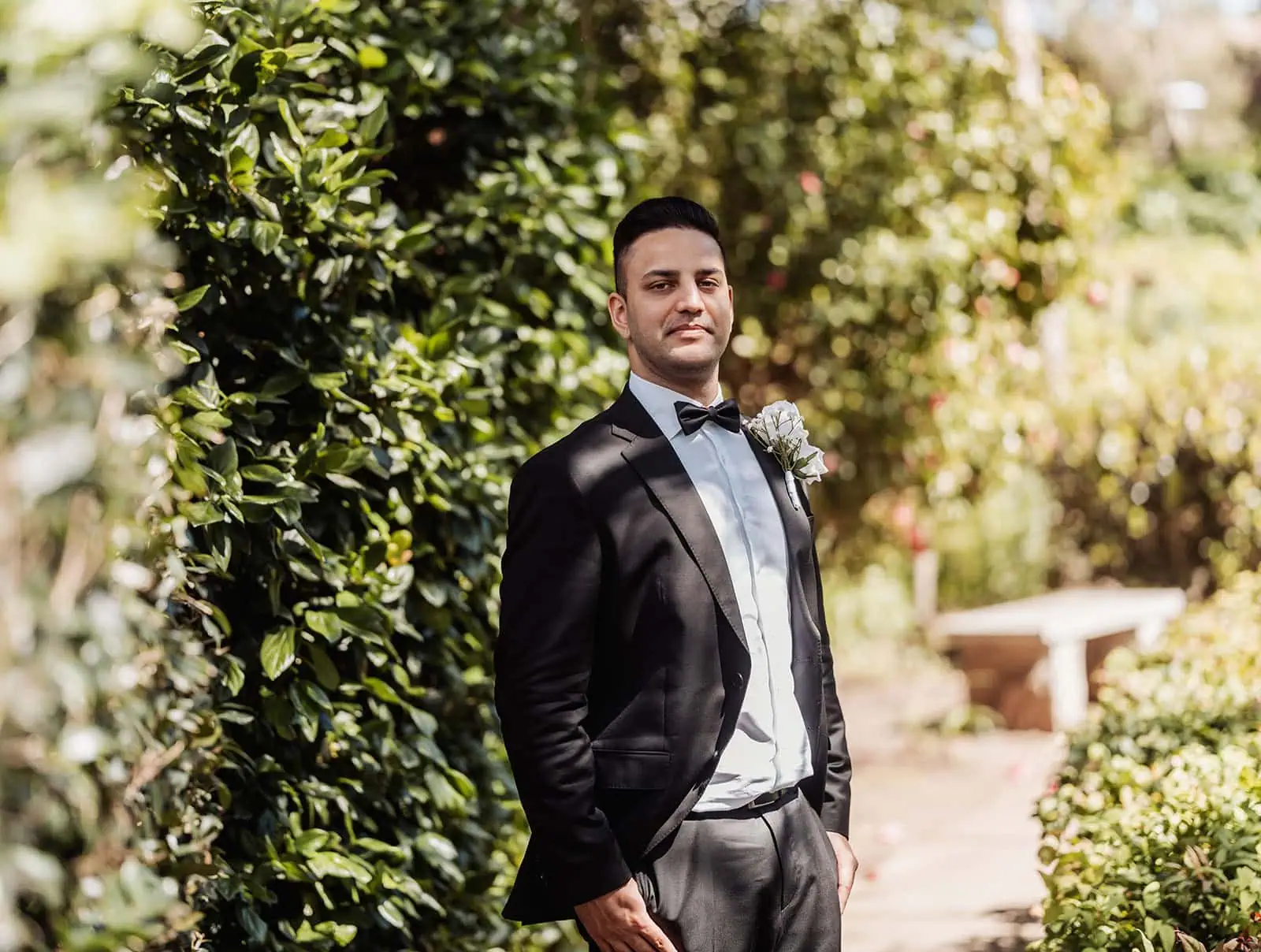 sunnybrae rose garden wedding - celina & anuj 31 Elegant formal garden with manicured hedges, colorful flowers, and symmetrical design.