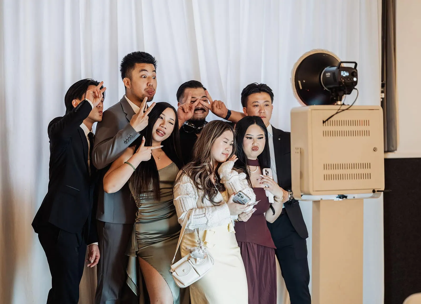 sunnybrae rose garden wedding - celina & anuj 71 Group enjoying photo booth fun at event, smiles and props abound.