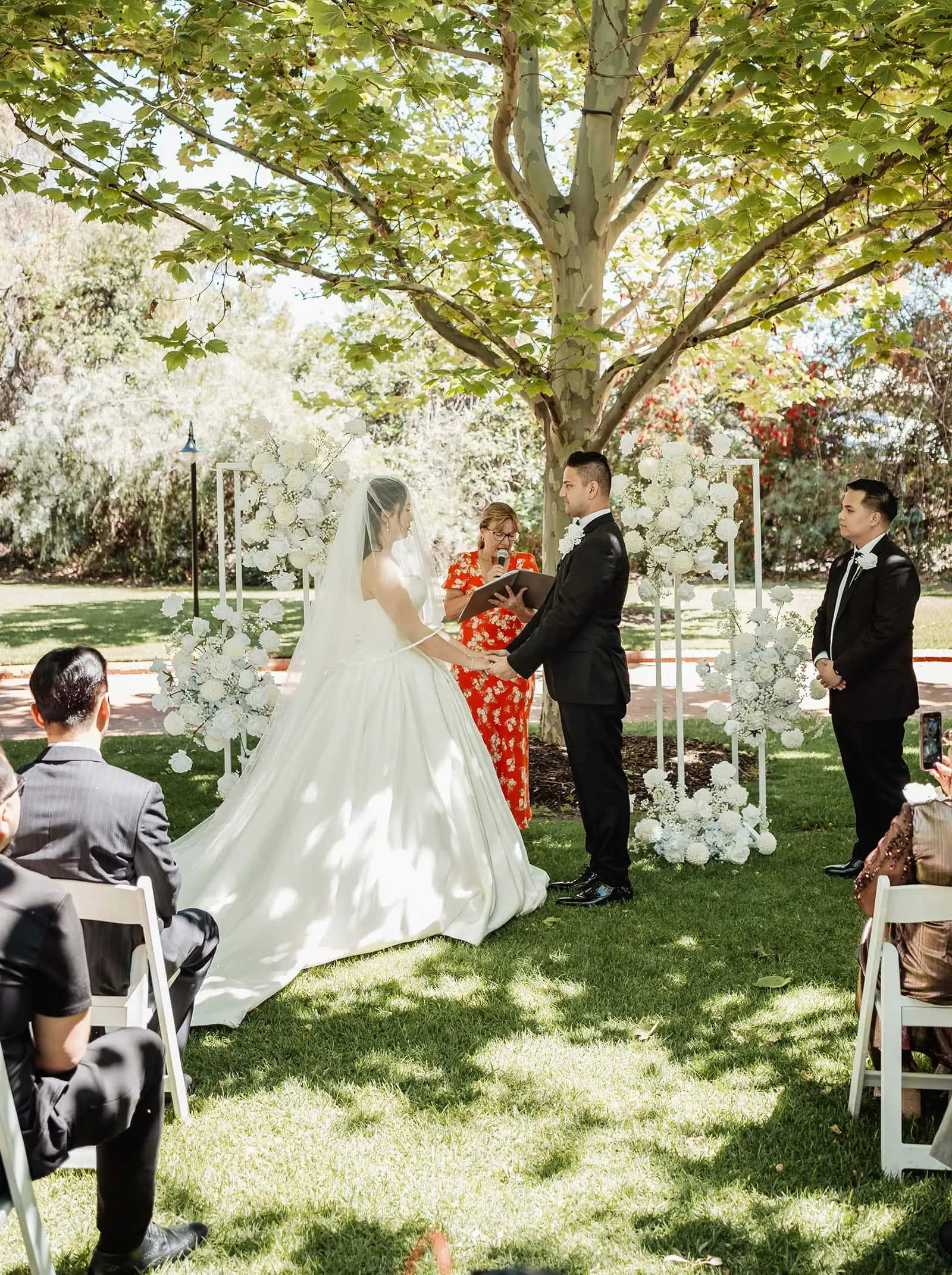 sunnybrae rose garden wedding - celina & anuj 44 Scenic outdoor wedding ceremony with lush greenery, elegant seating, and sunshine.