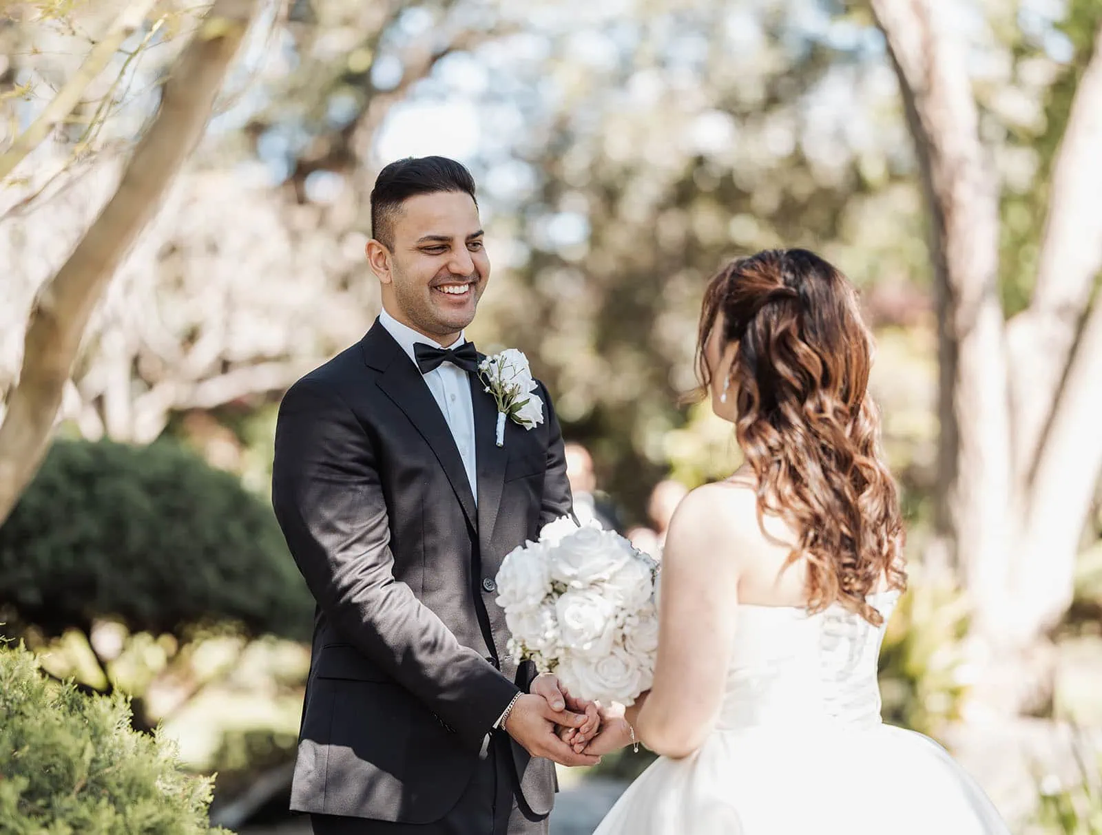 sunnybrae rose garden wedding - celina & anuj 20 Bride and groom embrace in a blooming garden, surrounded by vibrant flowers.