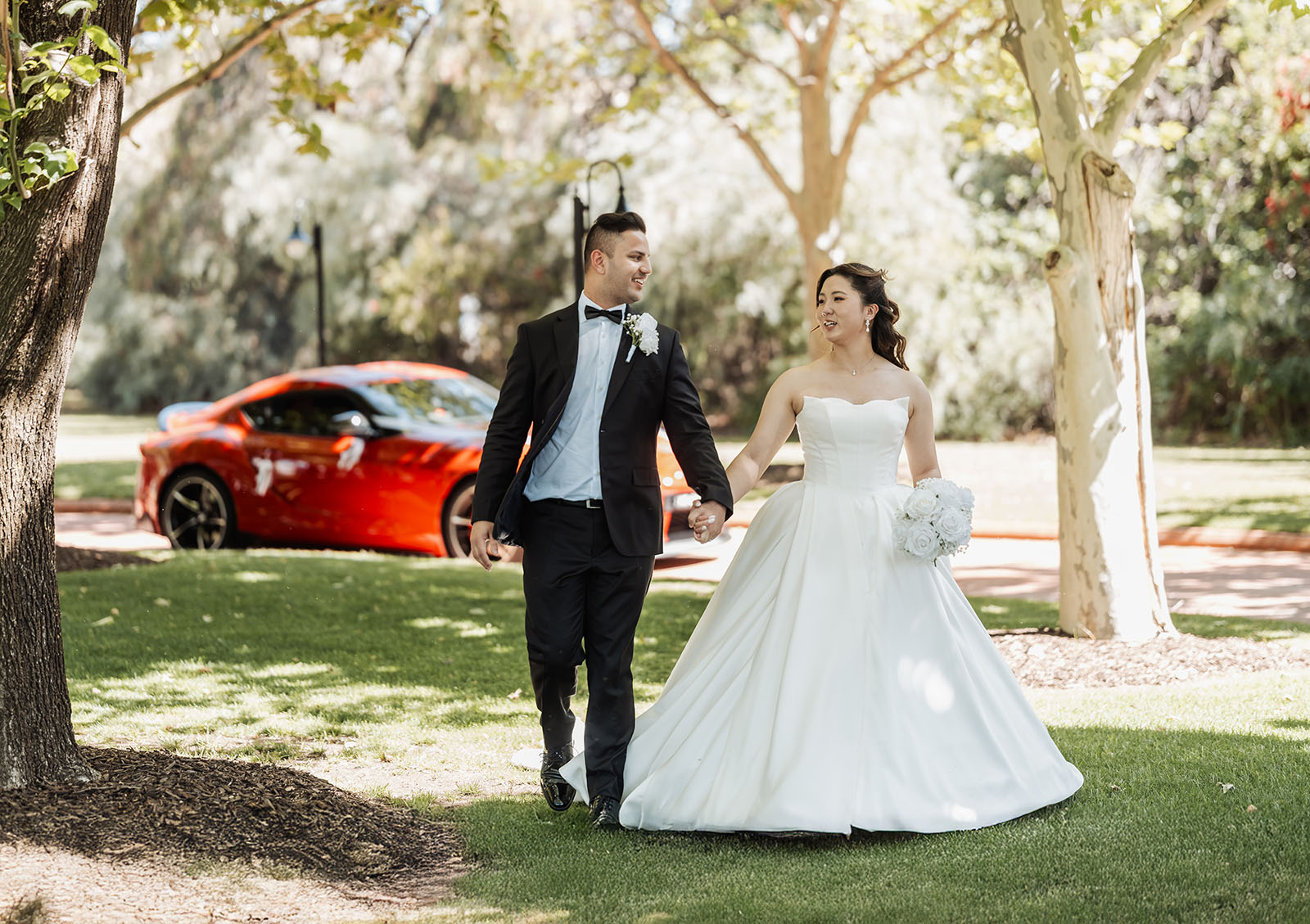 sunnybrae rose garden wedding - celina & anuj 51 Bride and groom smiling on a sunny green lawn at outdoor wedding.