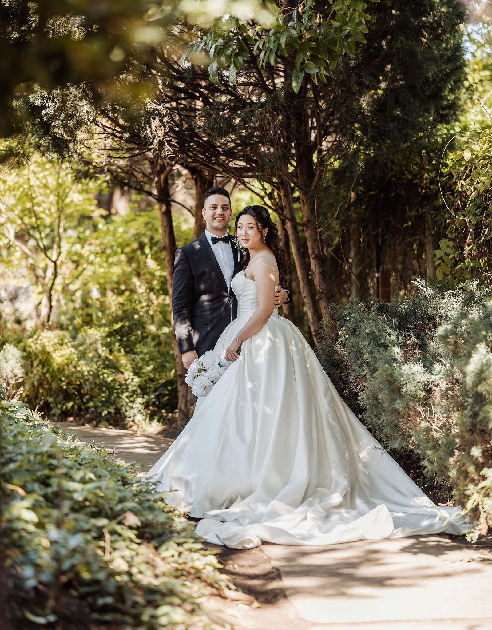sunnybrae rose garden wedding - celina & anuj 24 Bride and groom smiling against a scenic outdoor backdrop.