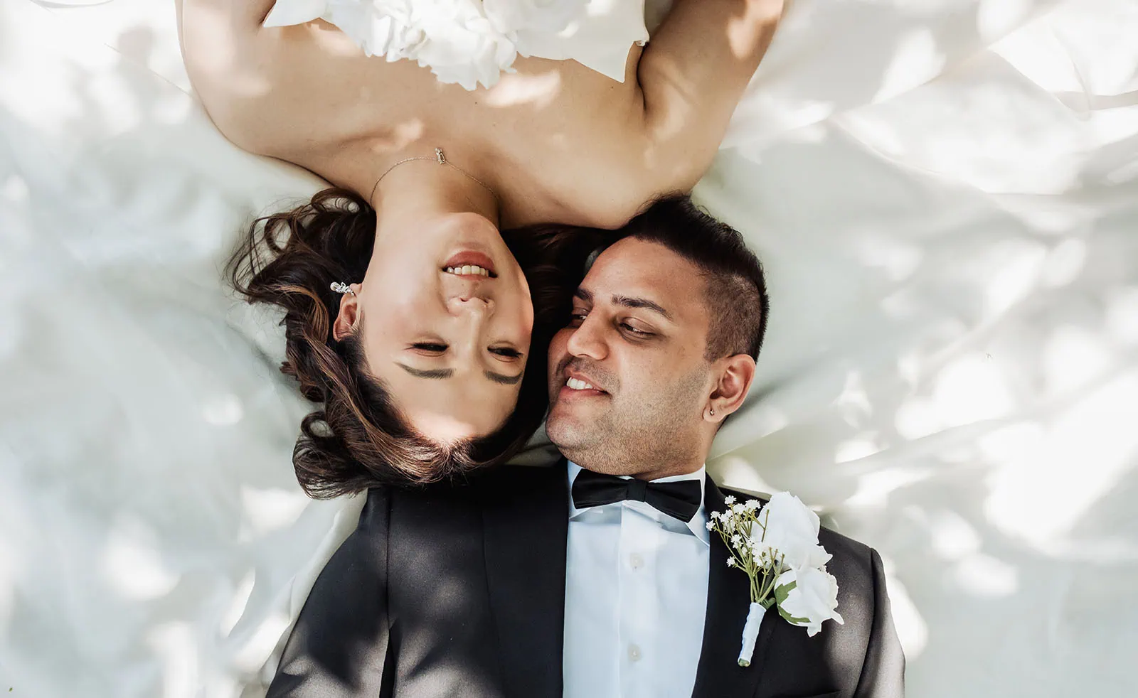 sunnybrae rose garden wedding - celina & anuj 36 Bride and groom embrace, smiling joyfully in elegant wedding attire.
